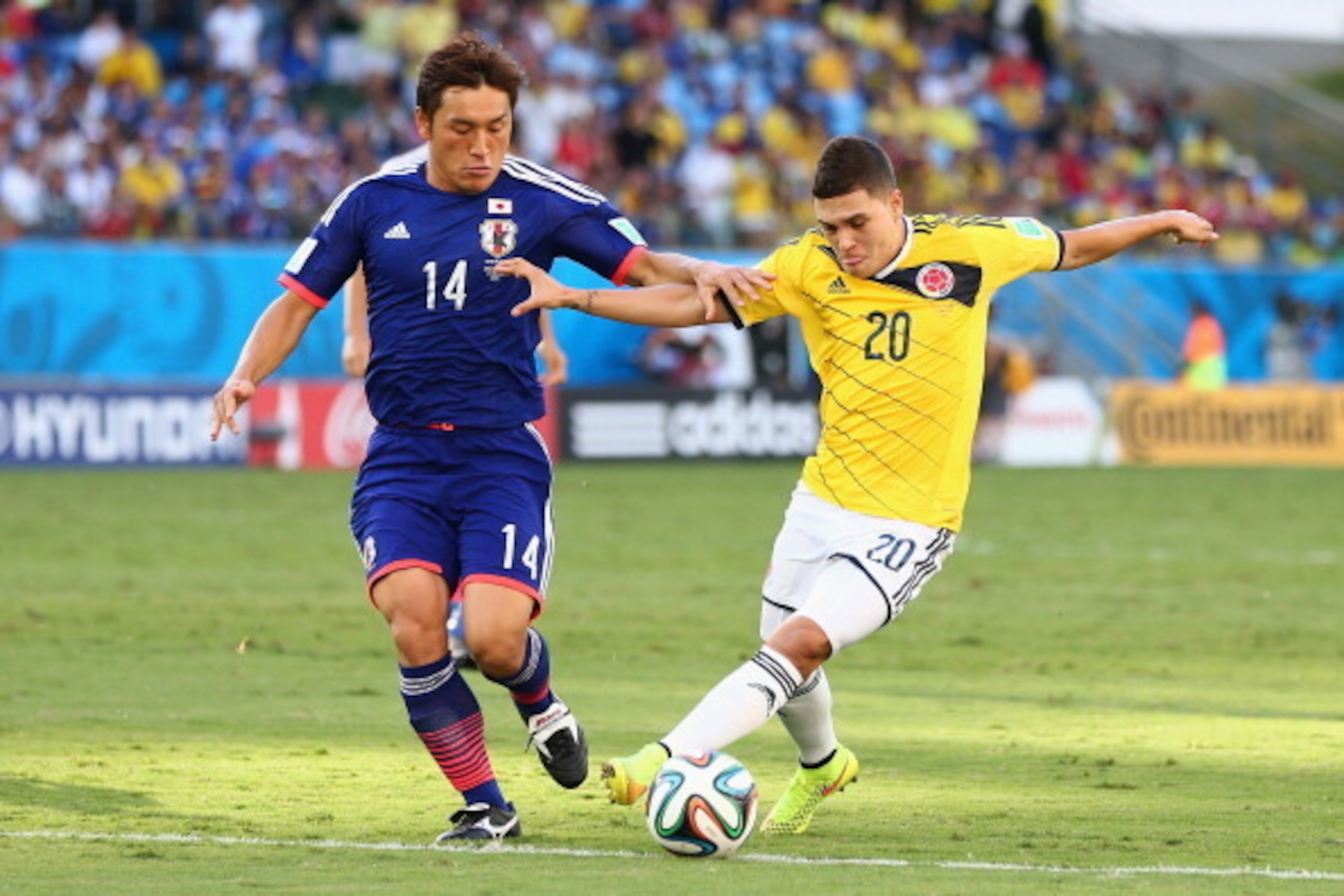 CUIABA, BRAZIL - JUNE 24:  Juan Fernando Quintero of Colombia holds off Toshihiro Aoyama of Japan during the 2014 FIFA World Cup Brazil Group C match between Japan and Colombia at Arena Pantanal on June 24, 2014 in Cuiaba, Brazil.  (Photo by Elsa/Getty Im