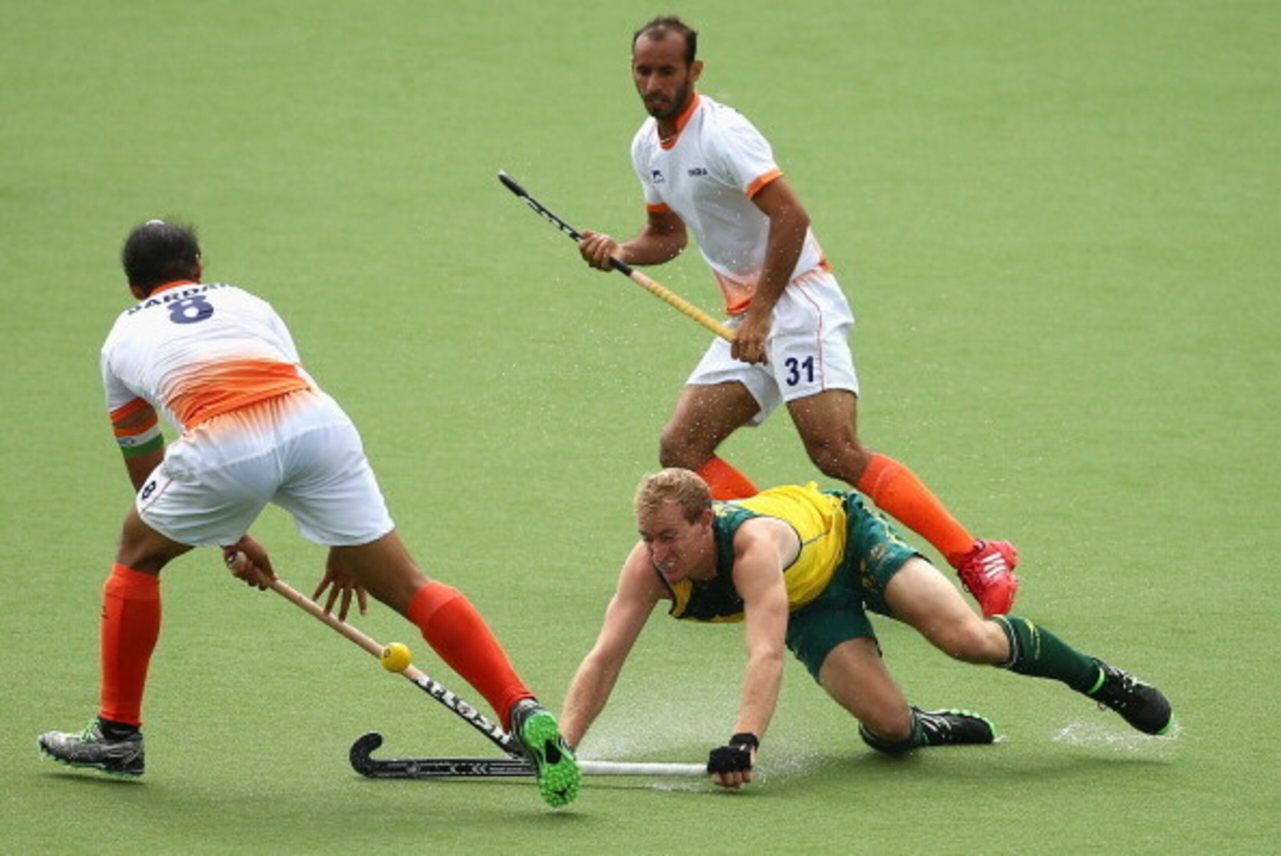 GLASGOW, SCOTLAND - JULY 29:  Aran Zalewski of Australia slips as he reaches for the ball during the men's preliminaries match between India and Australia at the Glasgow National Hockey Centre during day six of the Glasgow 2014 Commonwealth Games on July 