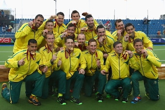 GLASGOW, SCOTLAND - AUGUST 03:  The Australia team celebrate with their Gold Medals after winning the Men's Gold Medal Match Final between India and Australia at Glasgow National Hockey Centre during day eleven of the Glasgow 2014 Commonwealth Games on Au