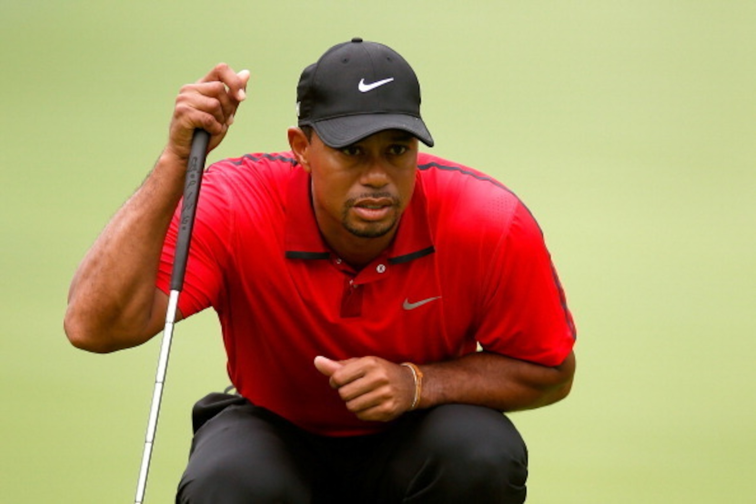 AKRON, OH - AUGUST 03:  Tiger Woods lines up a putt on the first green during the final round of the World Golf Championships-Bridgestone Invitational at Firestone Country Club South Course on August 3, 2014 in Akron, Ohio.  (Photo by Gregory Shamus/Getty