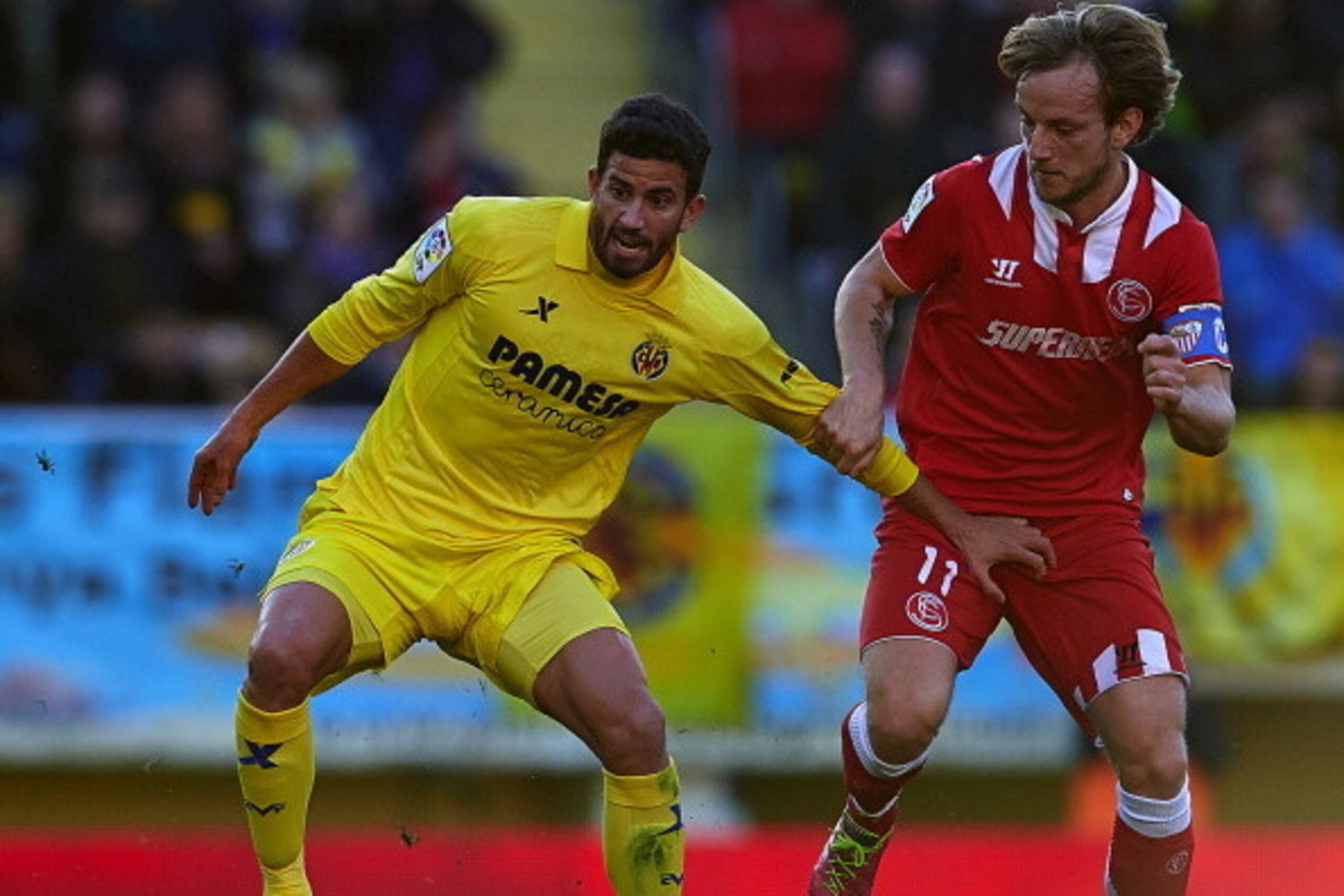 VILLARREAL, SPAIN - DECEMBER 21:  Mateo Musacchio (L) of Villarreal competes for the ball with Ivan Rakitic of Sevilla during the La Liga match between Villarreal CF and Sevilla FC at El Madrigal on December 21, 2013 in Villarreal, Spain.  (Photo by Manue