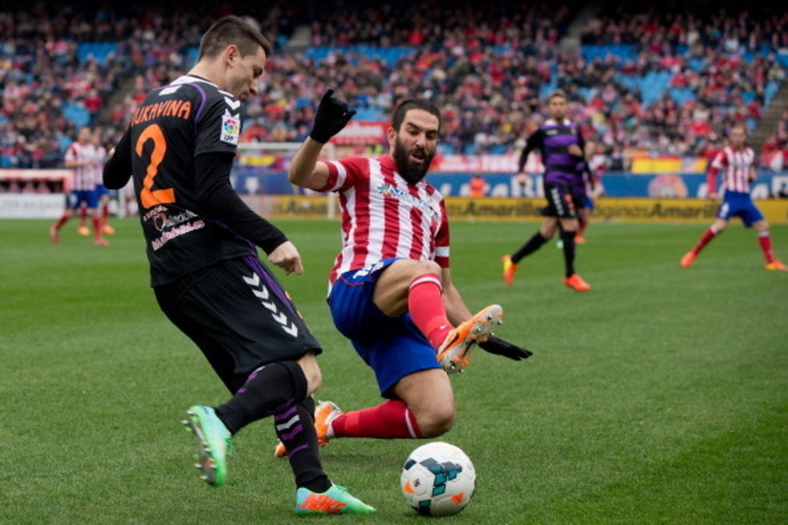 MADRID, SPAIN - FEBRUARY 15: Arda Turan (R) of Atletico de Madrid competes for the ball with Antonio Rukavina (L) of Real Valladolid CF during the La Liga match between Club Atletico de Madrid and Real Valladolid CF  at Vicente Calderon Stadium on Februar