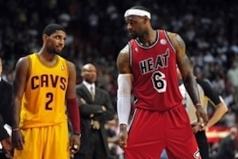 Feb 24, 2013; Miami, FL, USA; Cleveland Cavaliers point guard Kyrie Irving (left) looks over at Miami Heat small forward LeBron James (right) as Cleveland Cavaliers head coach Byron Scott (center) looks on during the second half at the American Airlines A