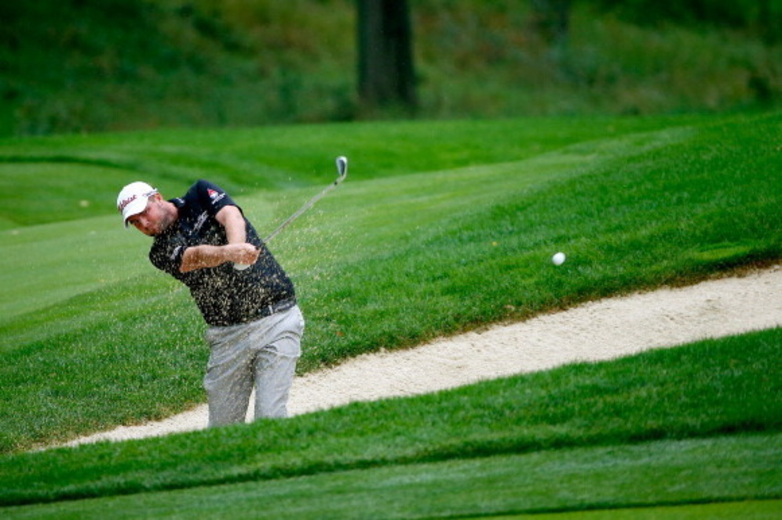 AKRON, OH - AUGUST 02: Marc Leishman of Australia hits out of a bunker on the 16th hole during the third round of the World Golf Championships-Bridgestone Invitational at Firestone Country Club South Course on August 2, 2014 in Akron, Ohio.  (Photo by Sam