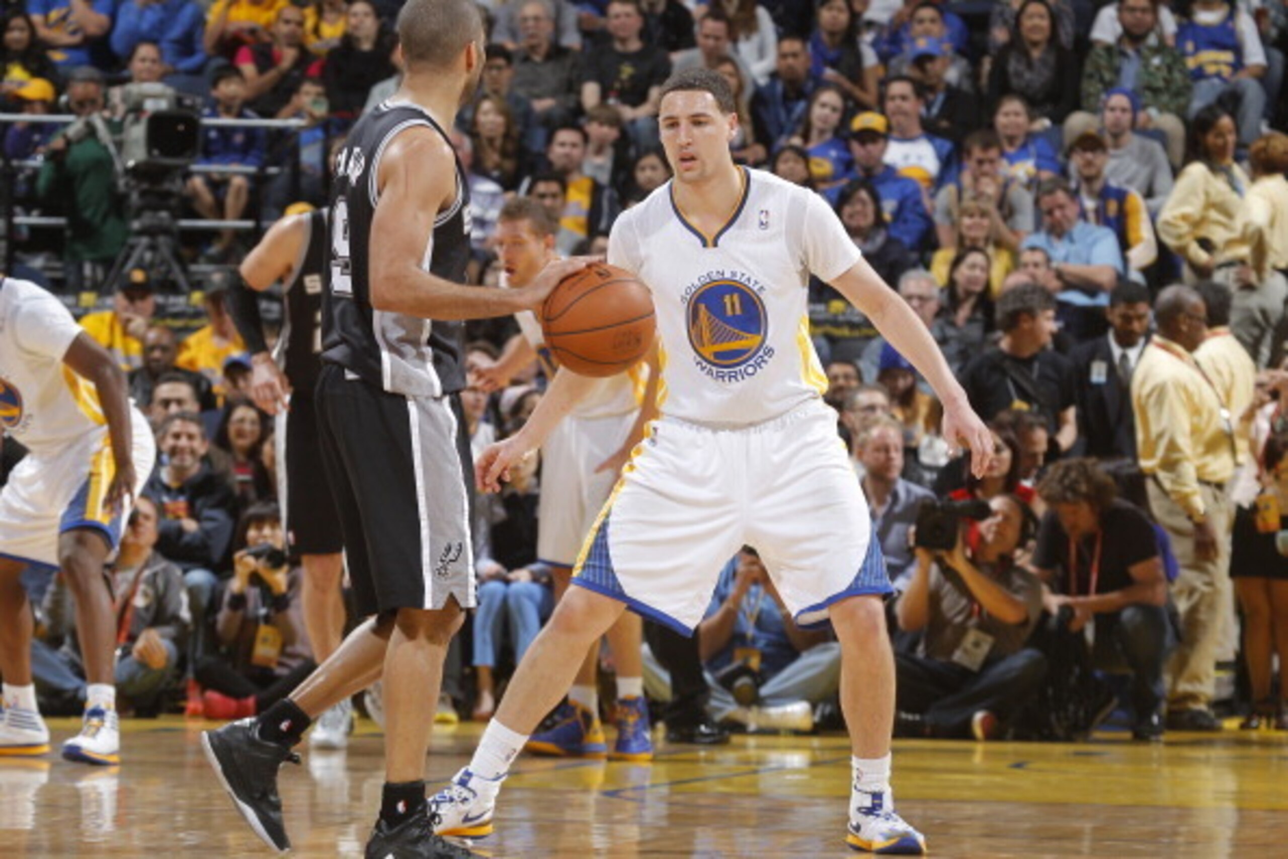 OAKLAND, CA - MARCH 22: Klay Thompson #11 of the Golden State Warriors defends Tony Parker #9 of the San Antonio Spurs on March 22, 2014 at Oracle Arena in Oakland, California. NOTE TO USER: User expressly acknowledges and agrees that, by downloading and 