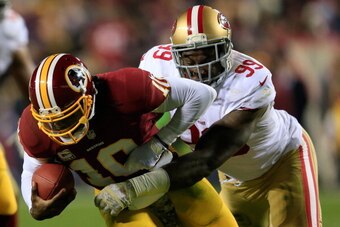LANDOVER, MD - NOVEMBER 25: Quarterback Robert Griffin III #10 of the Washington Redskins is sacked by outside linebacker Aldon Smith #99 of the San Francisco 49ers during the third quarter at FedExField on November 25, 2013 in Landover, Maryland.  (Photo