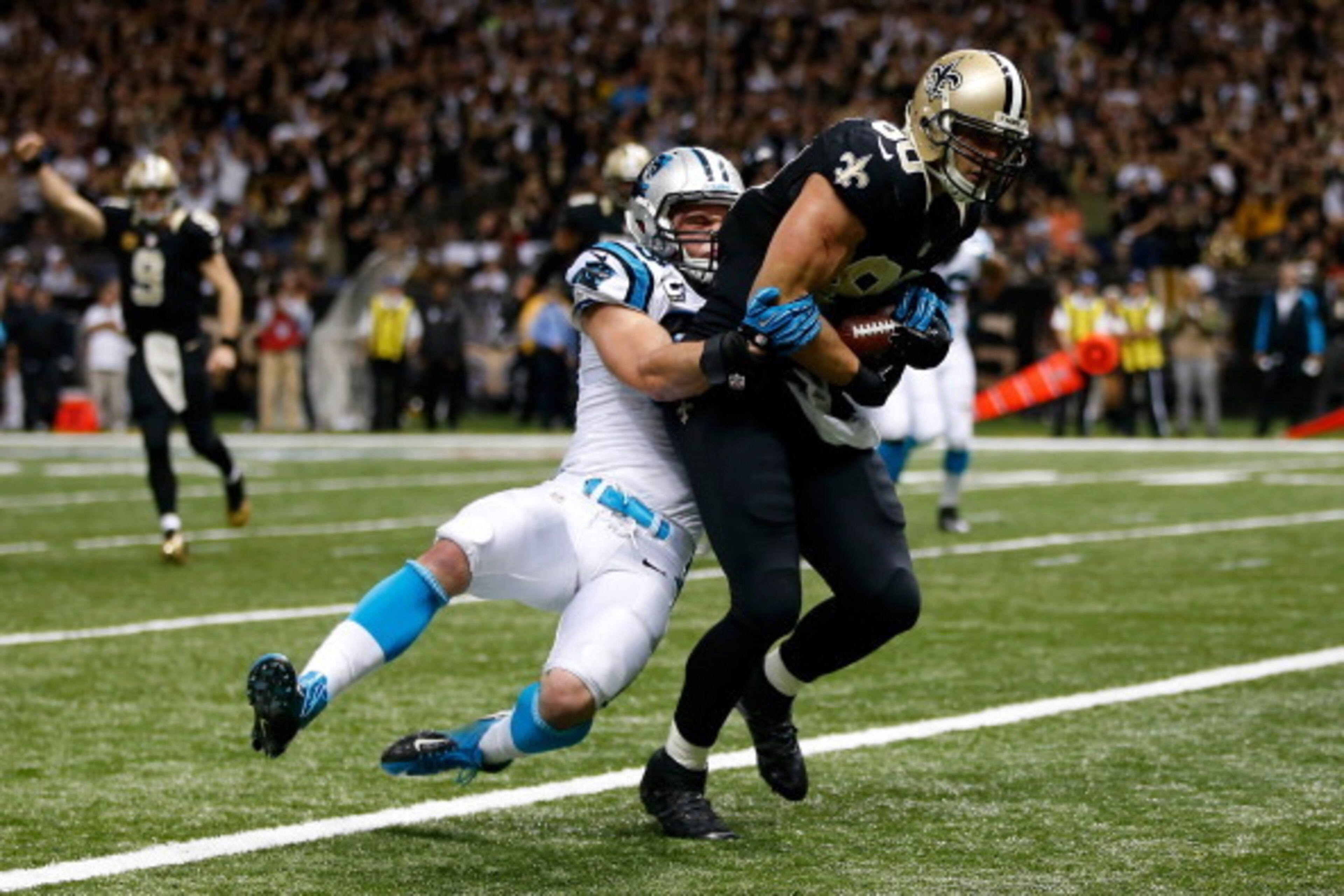NEW ORLEANS, LA - DECEMBER 08:  Jimmy Graham #80 of the New Orleans Saints is tackled as he scores a touchdown by  Luke Kuechly #59 of the Carolina Panthers at Mercedes-Benz Superdome on December 8, 2013 in New Orleans, Louisiana.  (Photo by Chris Graythe