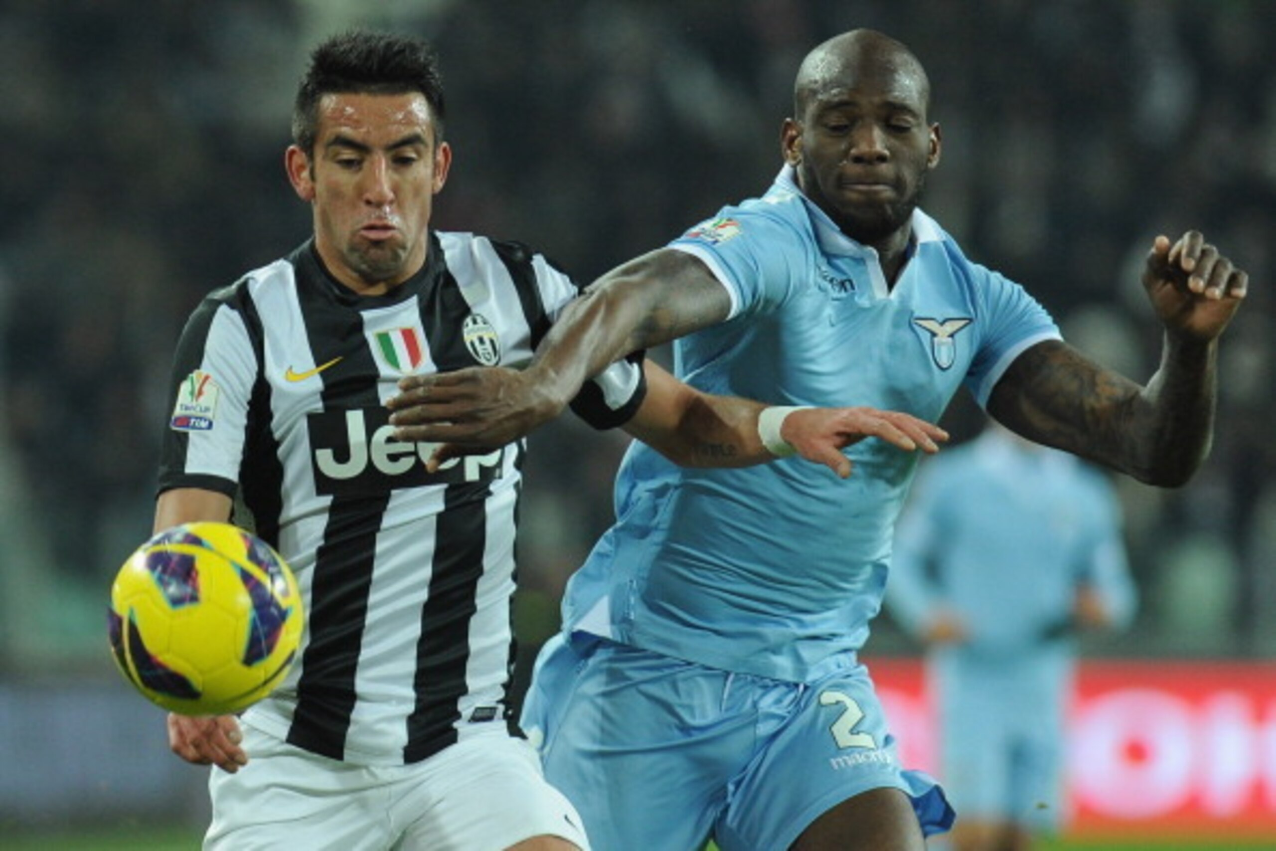TURIN, ITALY - JANUARY 22:  Mauricio Isla (L) of Juventus FC competes with Michael Ciani of S.S. Lazio during the TIM cup match between Juventus FC and S.S. Lazio at Juventus Arena on January 22, 2013 in Turin, Italy.  (Photo by Valerio Pennicino/Getty Im