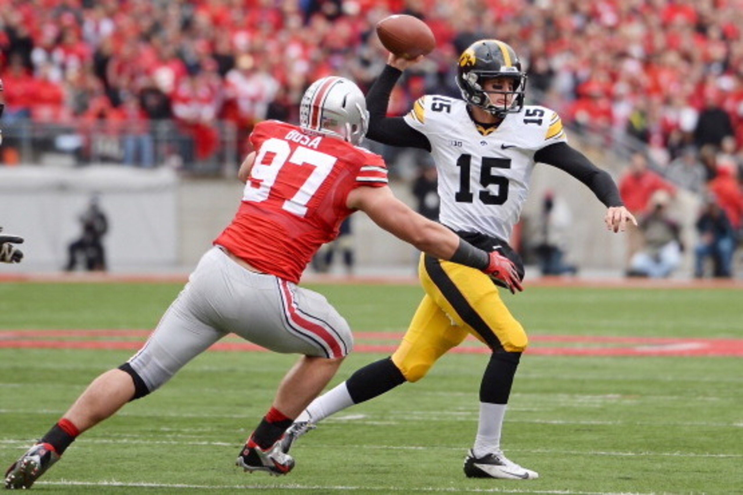 COLUMBUS, OH - OCTOBER 19:  Quarterback Jake Rudock #15 of the Iowa Hawkeyes passes in the second quarter as Joey Bosa #97 of the Ohio State Buckeyes applies pressure at Ohio Stadium on October 19, 2013 in Columbus, Ohio.  Ohio State defeated Iowa 34-24. 