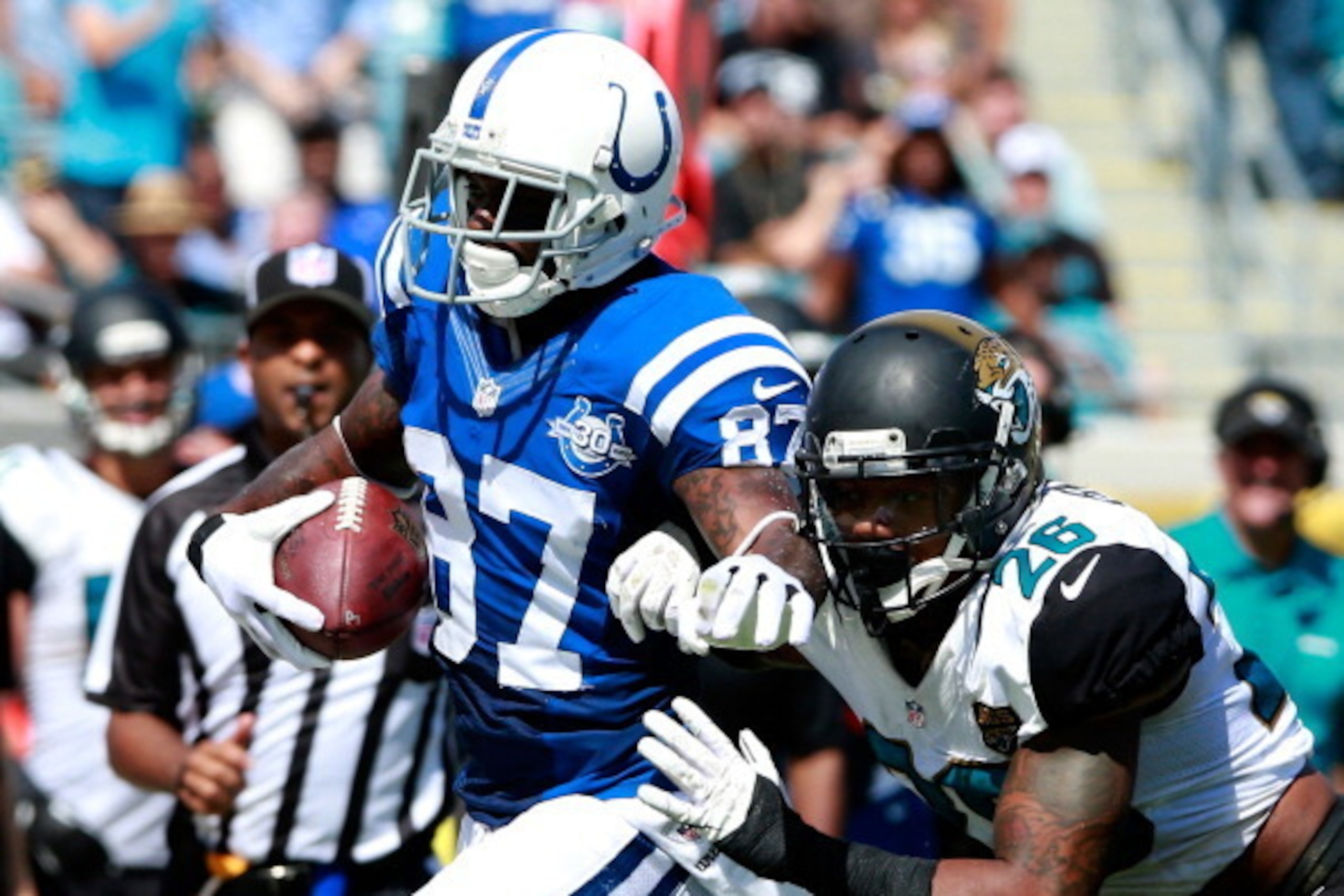 JACKSONVILLE, FL - SEPTEMBER 29:  Josh Evans #26 of the Jacksonville Jaguars attempts to tackle  Reggie Wayne #87 of the Indianapolis Colts during the game at EverBank Field on September 29, 2013 in Jacksonville, Florida.  (Photo by Sam Greenwood/Getty Im