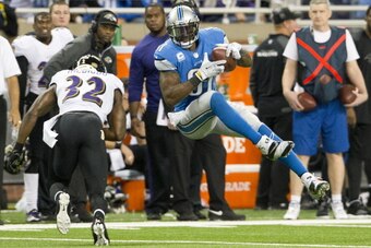 DETROIT, MI - DECEMBER 16: Wide receiver Calvin Johnson #81 of the Detroit Lions catches a pass under pressure from strong safety James Ihedigbo #32 of the Baltimore Ravens during the second half at Ford Field on December 16, 2013 in Detroit, Michigan. Th