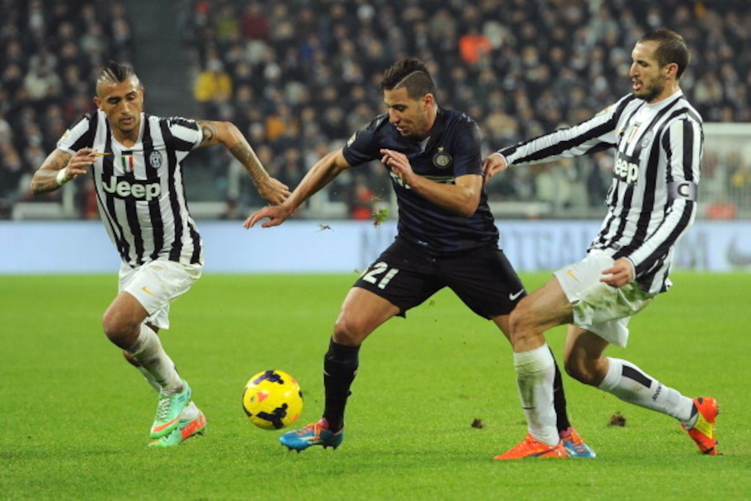 TURIN, ITALY - FEBRUARY 02:  Saphir Slitti Taider (C) of FC Internazionale Milano is challenged by Arturo Vidal (L) and Giorgio Chiellini of Juventus during the Serie A match between Juventus and FC Internazionale Milano at Juventus Arena on February 2, 2
