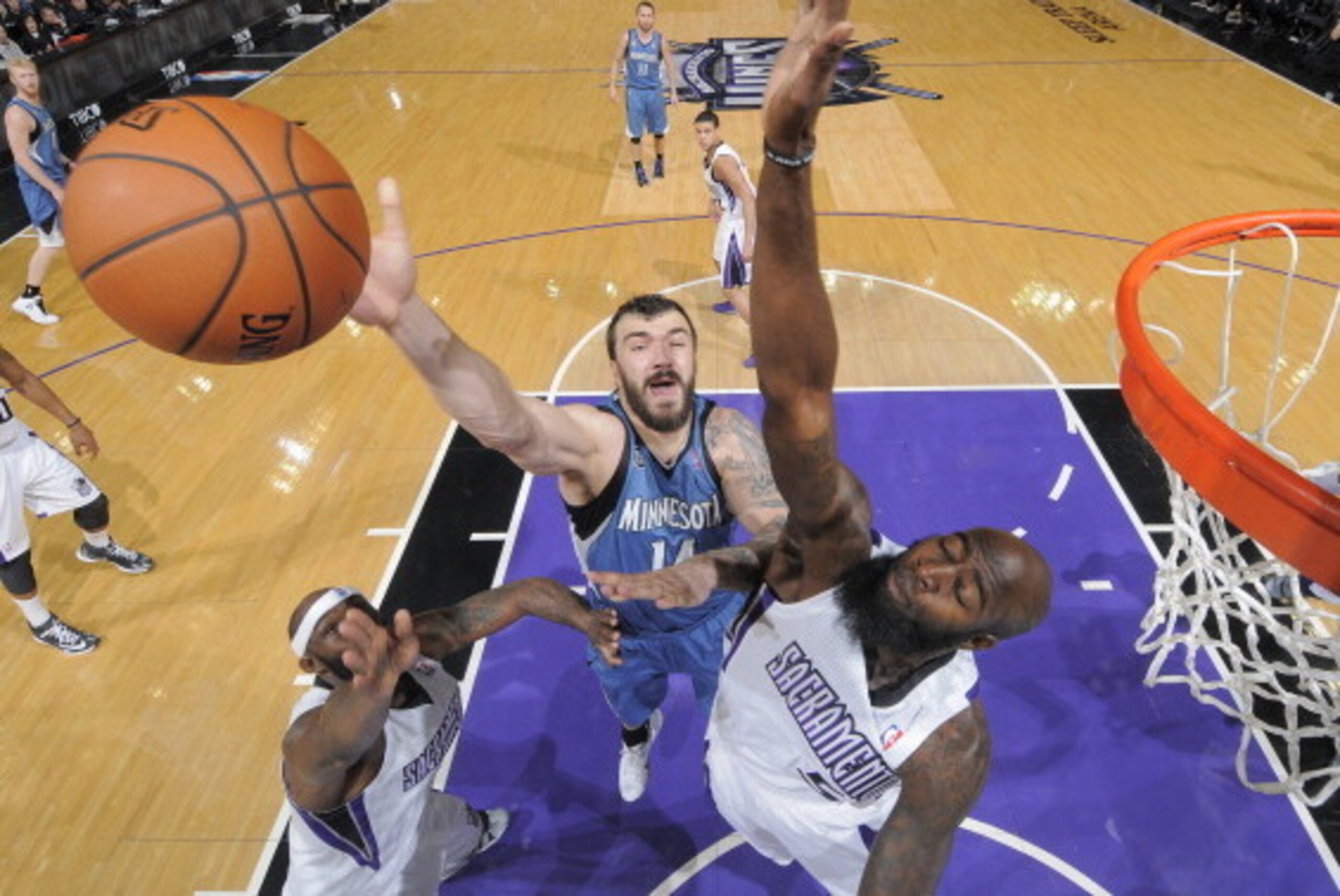 SACRAMENTO, CA - MARCH 1: Nikola Pekovic #14 of the Minnesota Timberwolves shoots against Reggie Evans #30 and Quincy Acy #5 of the Sacramento Kings on March 1, 2014 at Sleep Train Arena in Sacramento, California. NOTE TO USER: User expressly acknowledges