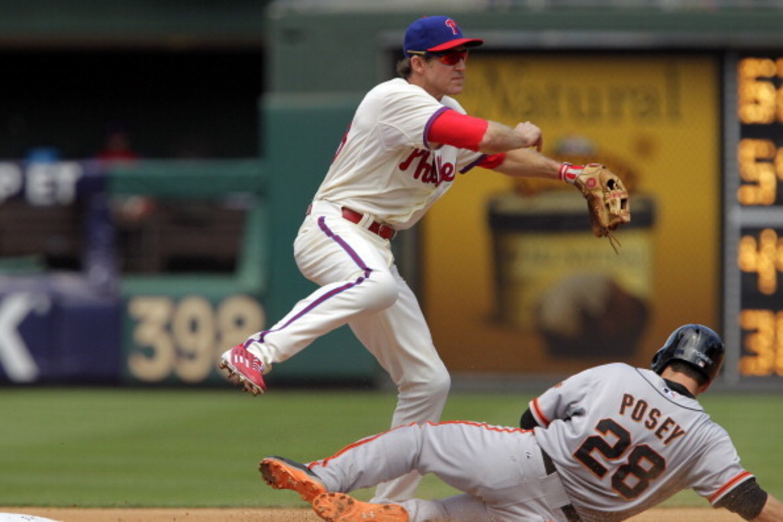 PHILADELPHIA - JULY 24: Chase Utley #26 of the Philadelphia Phillies attempts a double-play in the first inning as Buster Posey #28 of the San Francisco Giants slides into second base during a game at Citizens Bank Park on July 24, 2014 in Philadelphia, P