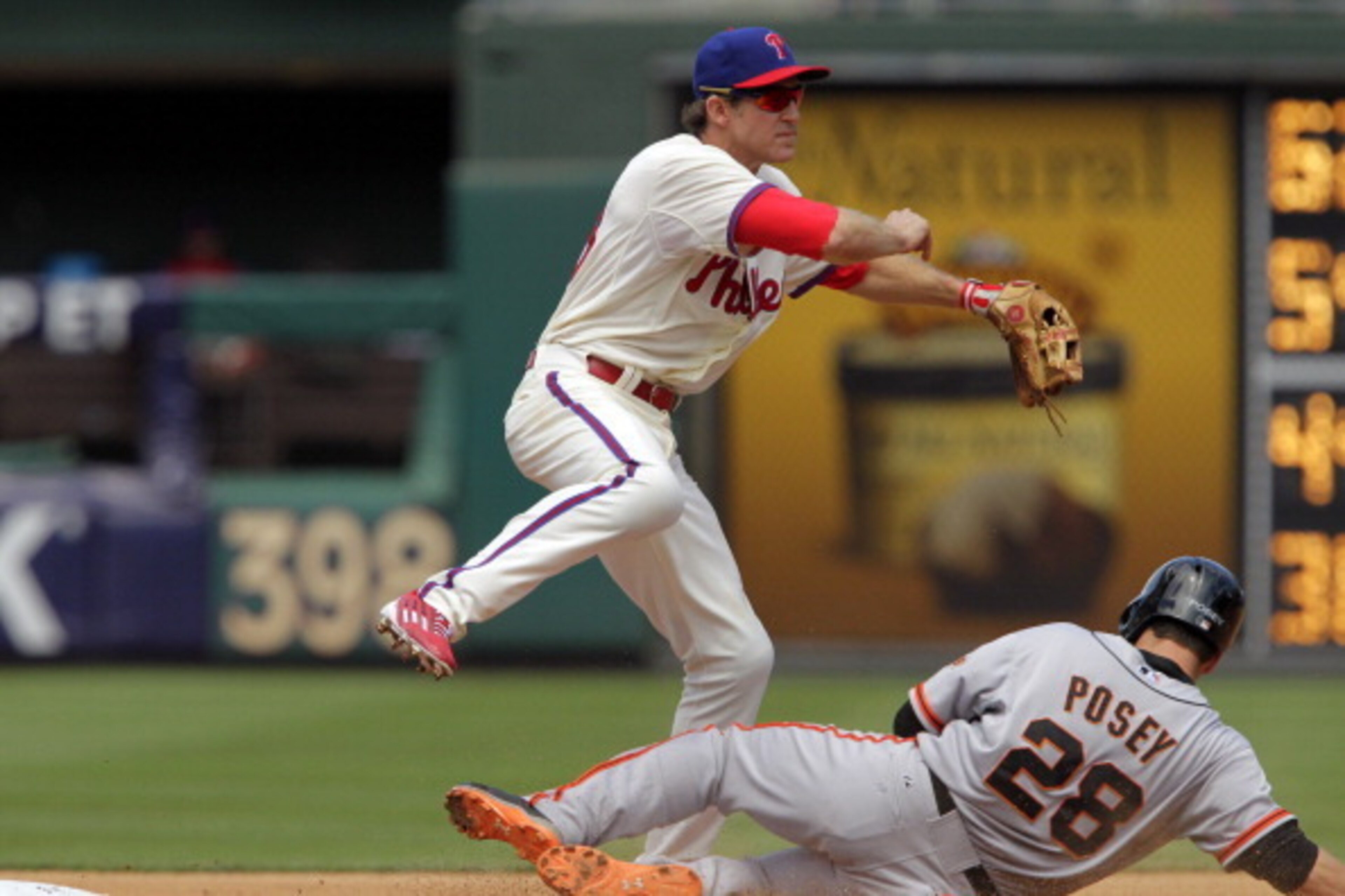 PHILADELPHIA - JULY 24: Chase Utley #26 of the Philadelphia Phillies attempts a double-play in the first inning as Buster Posey #28 of the San Francisco Giants slides into second base during a game at Citizens Bank Park on July 24, 2014 in Philadelphia, P
