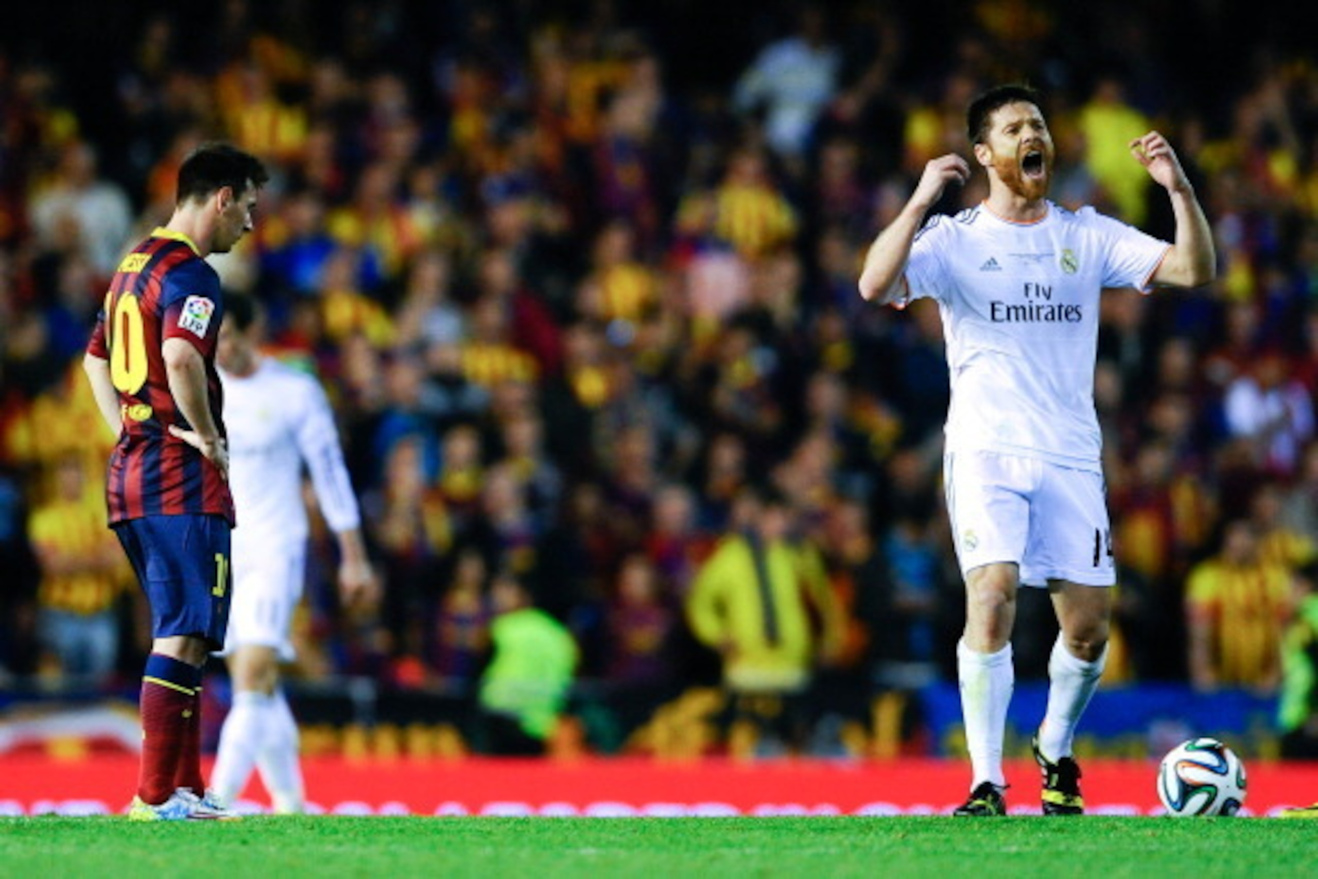 VALENCIA, SPAIN - APRIL 16:  Xabi Alonso of Real Madrid CF celebrates past Lionel Messi of FC Barcelona after his teammate Gareth Bale of Real Madrid CF scored the winning goal during the Copa del Rey Final between Real Madrid and FC Barcelona at Estadio 