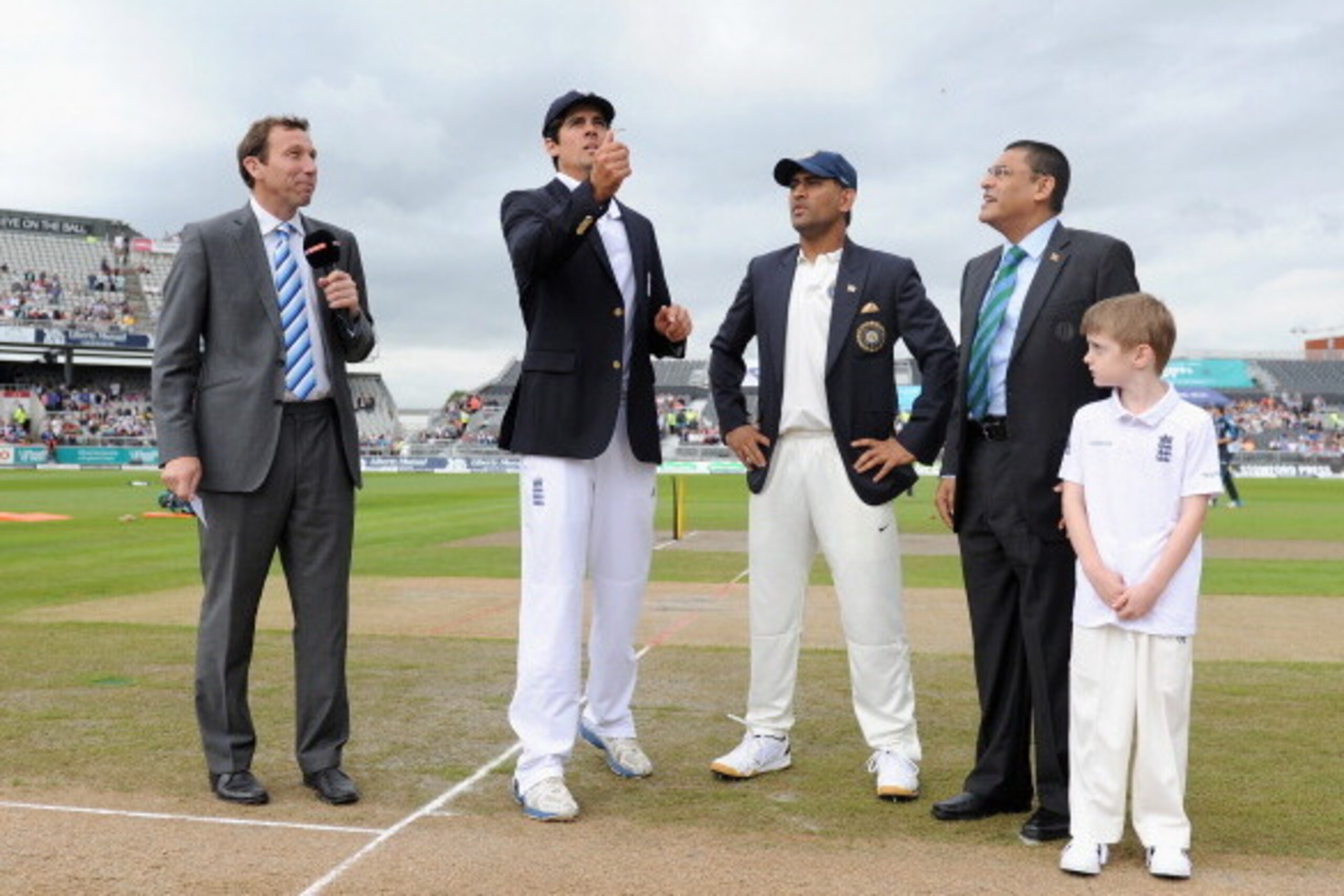 MANCHESTER, ENGLAND - AUGUST 07:  England captain Alastair Cook tosses the coin alongside Mahendra Singh Dhoni of India ahead of day one of 4th Investec Test match between England and India at Old Trafford on August 7, 2014 in Manchester, England.  (Photo