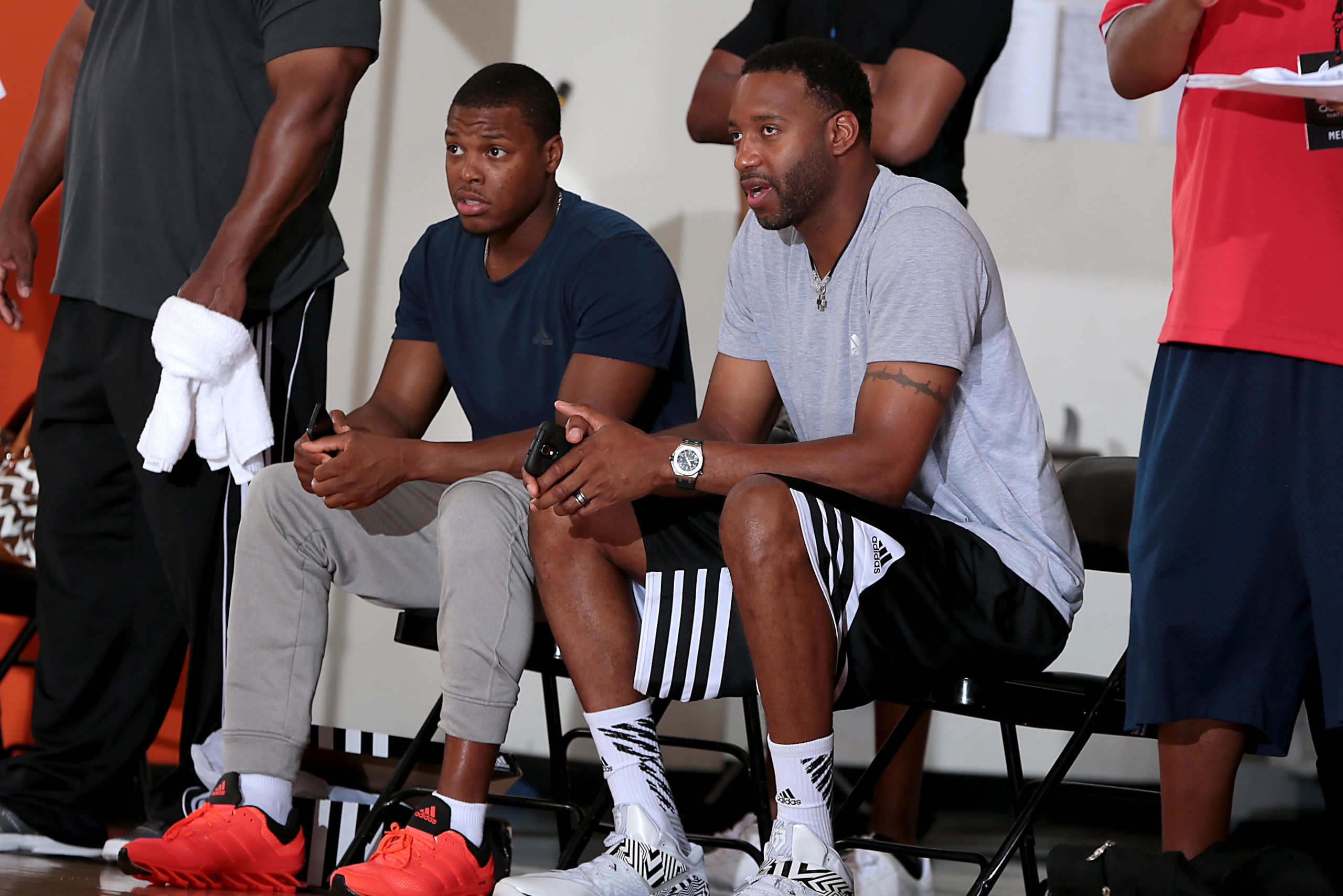 Kyle Lowry and Tracy McGrady watch from the sideline at Adidas Nations.