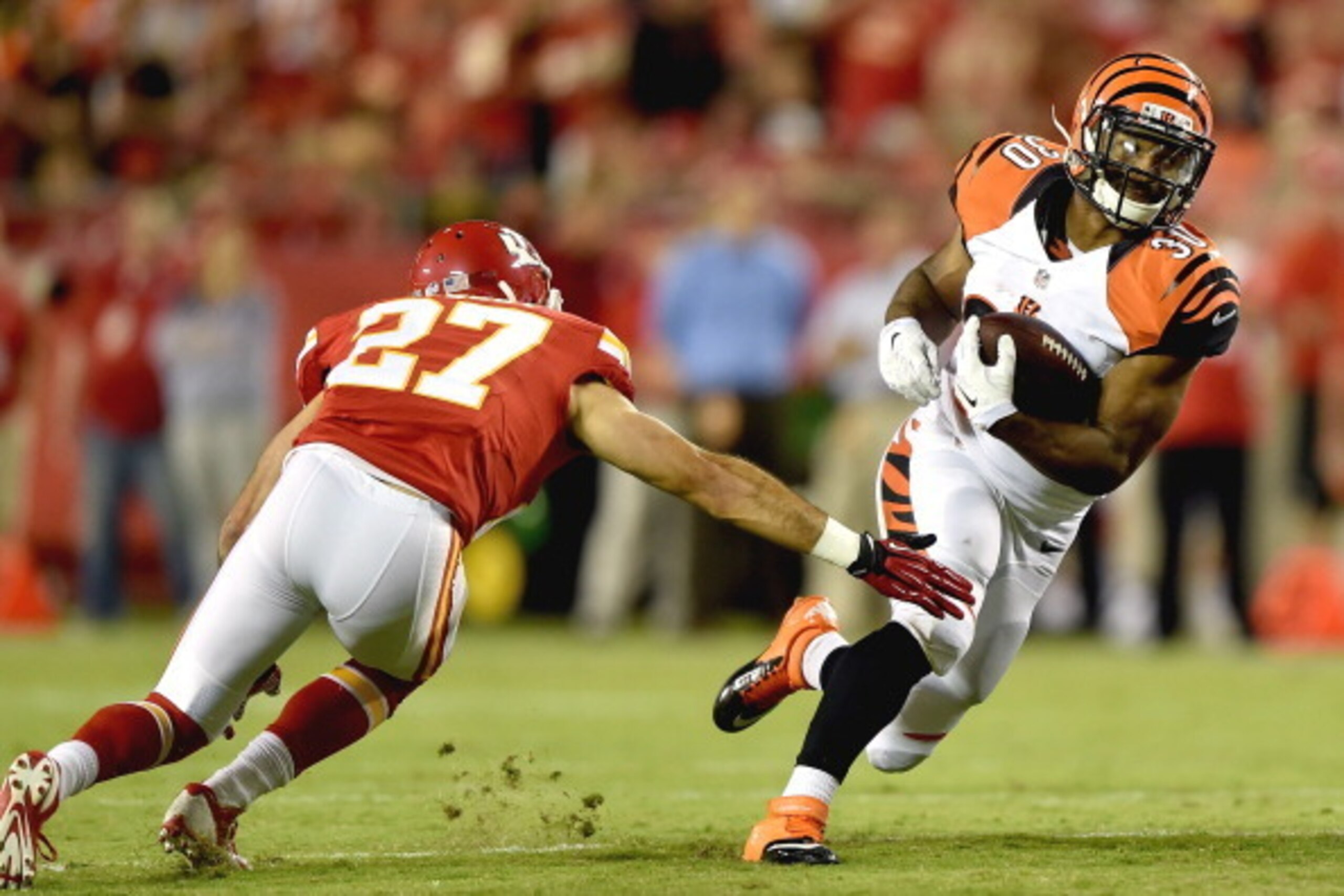 KANSAS CITY, MO - AUGUST 07: Cedric Peerman #30 of the Cincinnati Bengals runs the ball past Steve Gregory #27 of the Kansas City Chiefs at Arrowhead Stadium on August 7, 2014 in Kansas City, Missouri.  (Photo by Peter Aiken/Getty Images)