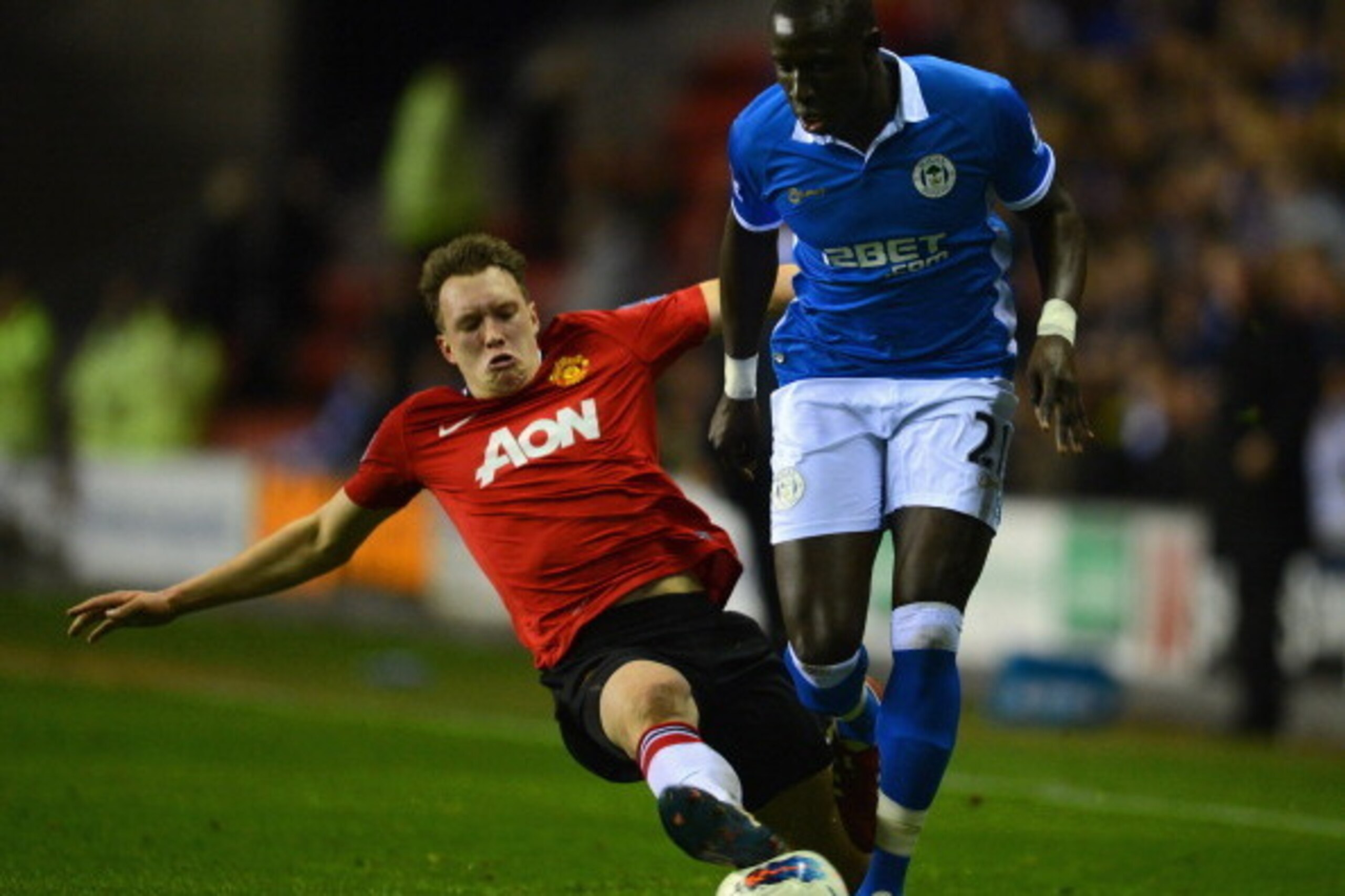 WIGAN, ENGLAND - APRIL 11: Phil Jones of Manchester United injures himself in a tackle on Mohamed Diame of Wigan during the Barclays Premier League match between Wigan Athletic and Manchester United at the DW Stadium on April 11, 2012 in Wigan, England. WIGAN, ENGLAND - APRIL 11: Phil Jones of Manchester United injures himself in a tackle on Mohamed Diame of Wigan during the Barclays Premier League match between Wigan Athletic and Manchester United at the DW Stadium on April 11, 2012 in Wigan, England.