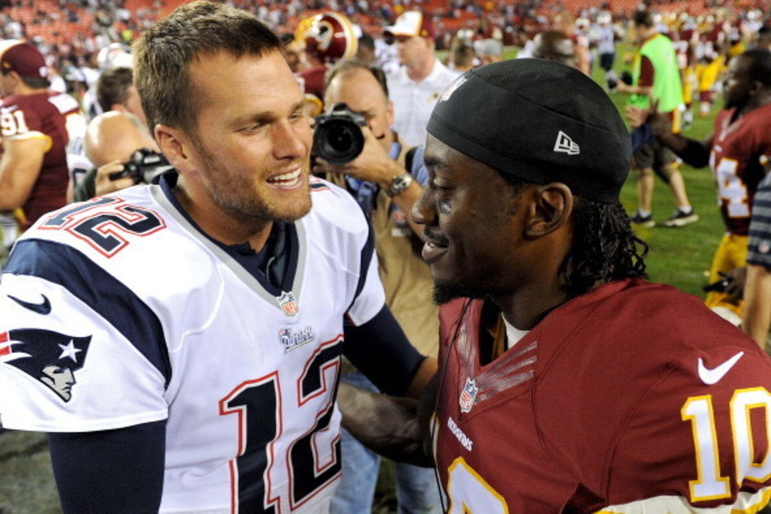 LANDOVER, MD - AUGUST 07: Quarterback Tom Brady #12 of the New England Patriots and quarterback Robert Griffin III #10 of the Washington Redskins talk following a preseason NFL game at FedExField on August 7, 2014 in Landover, Maryland. The Washington Red