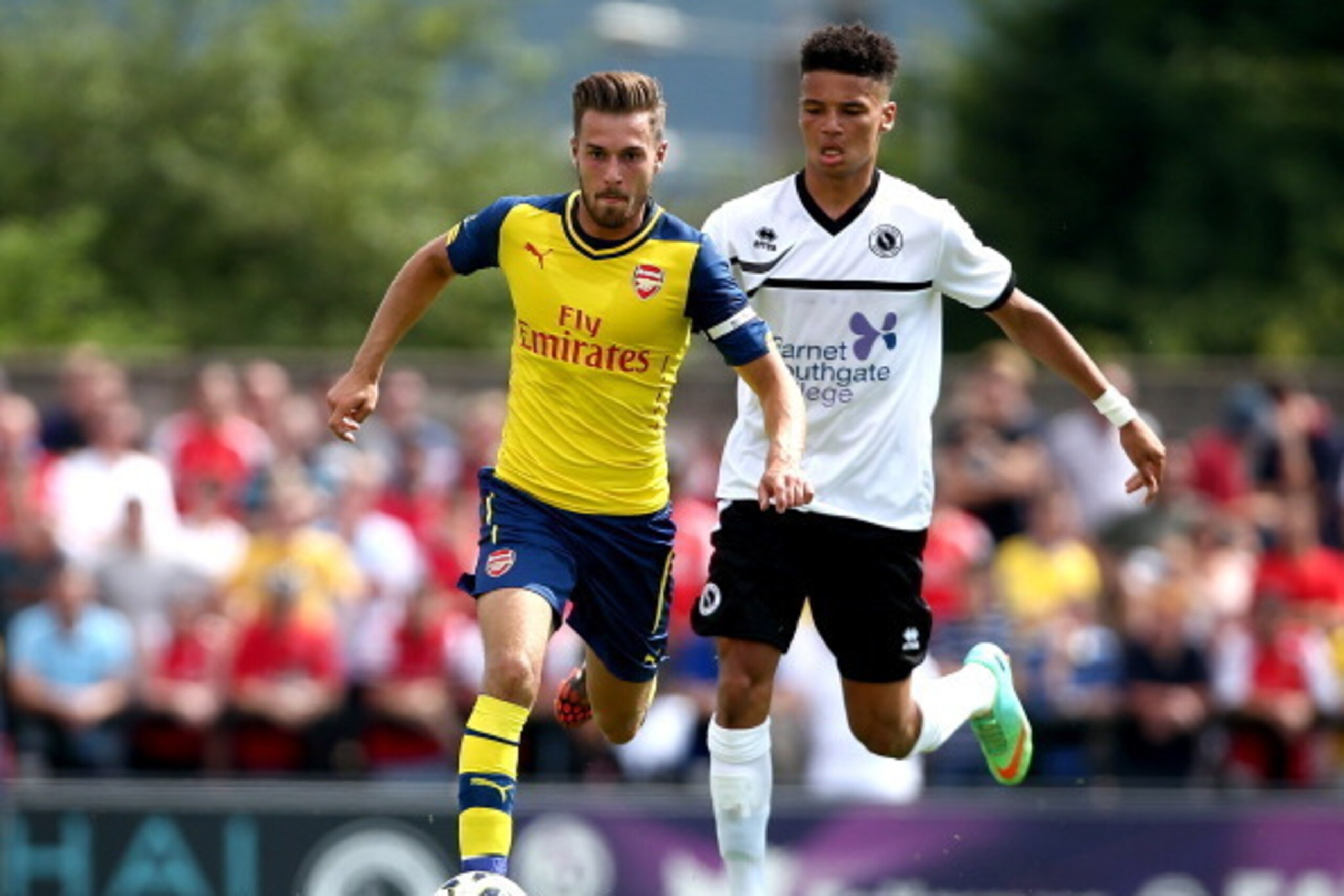 BOREHAMWOOD, ENGLAND - JULY 19:  Aaron Ramsey of Arsenal tackles with Lee Angol of Boreham Wood during the pre season friendly match between Borehamwood and Arsenal at Meadow Park on July 19, 2014 in Borehamwood, England.  (Photo by Jordan Mansfield/Getty