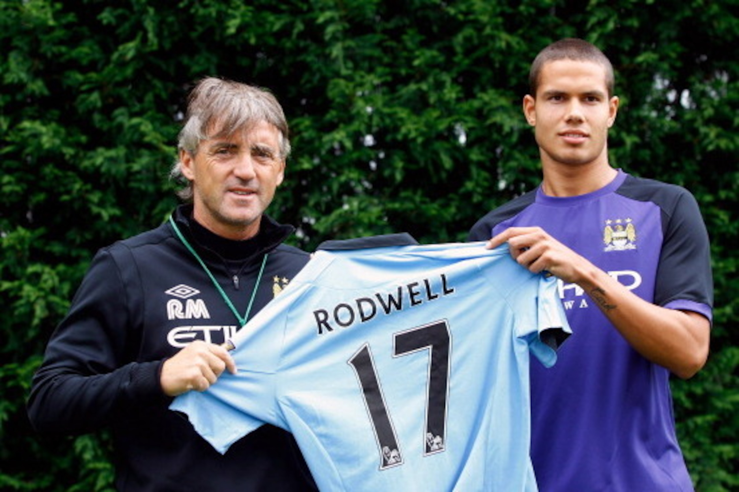 MANCHESTER, ENGLAND - AUGUST 17:  New Manchester City player Jack Rodwell (R) and manager manager Roberto Mancini pose for a photograph at the MCFC Carrington Training Complex on August 17, 2012 in Manchester, England. (Photo by Paul Thomas/Getty Images)