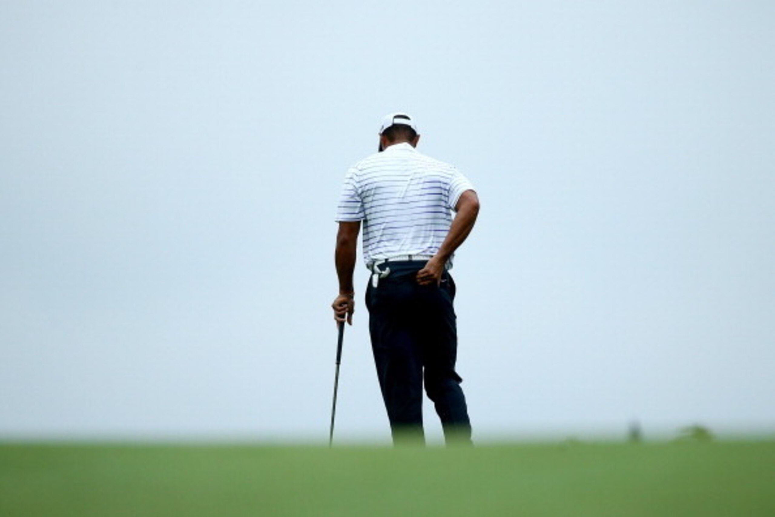 LOUISVILLE, KY - AUGUST 08:  Tiger Woods of the United States rubs his back before hitting his second shot on the 17th hole during the second round of the 96th PGA Championship at Valhalla Golf Club on August 8, 2014 in Louisville, Kentucky.  (Photo by An