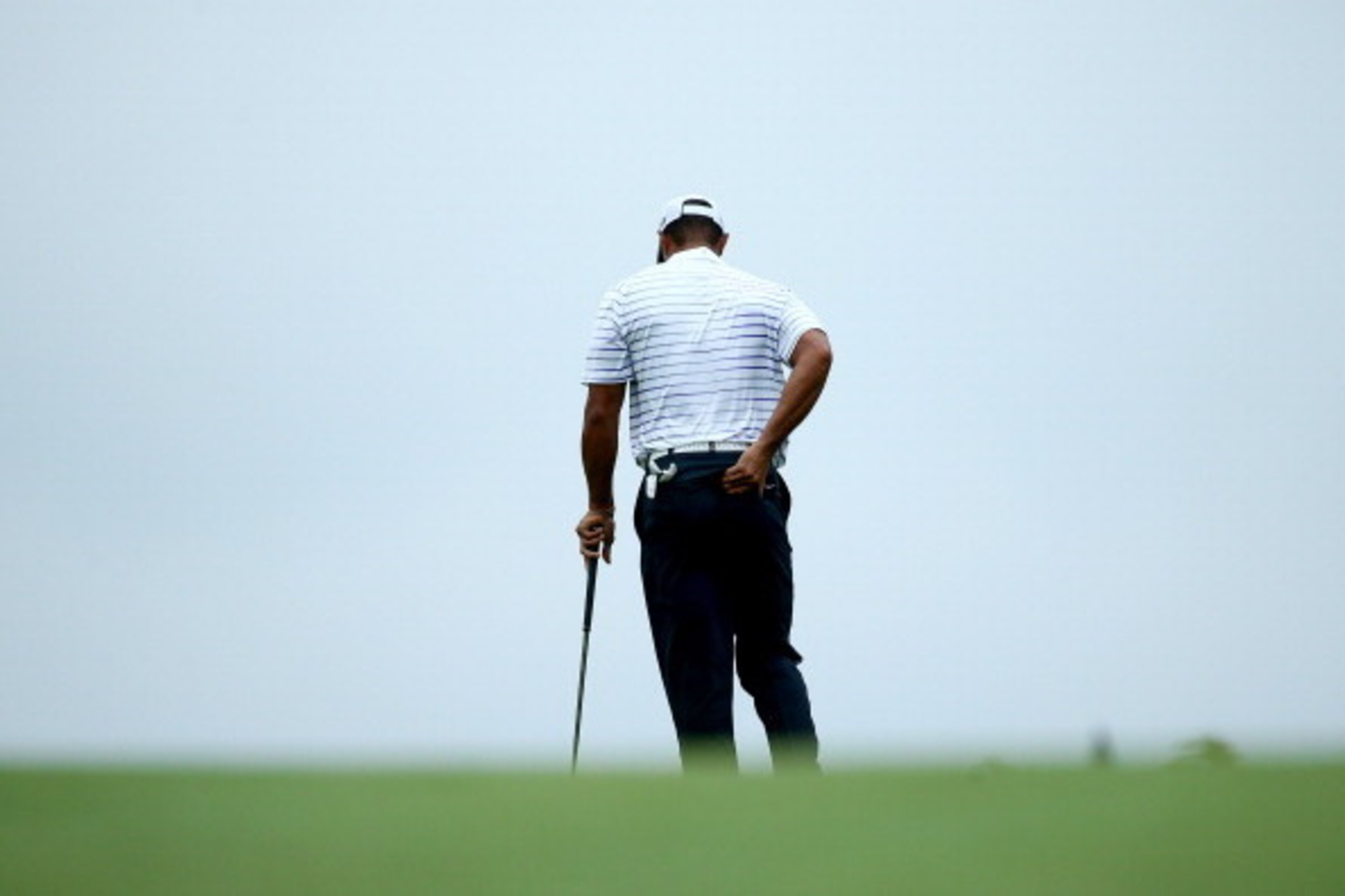 LOUISVILLE, KY - AUGUST 08:  Tiger Woods of the United States rubs his back before hitting his second shot on the 17th hole during the second round of the 96th PGA Championship at Valhalla Golf Club on August 8, 2014 in Louisville, Kentucky.  (Photo by An