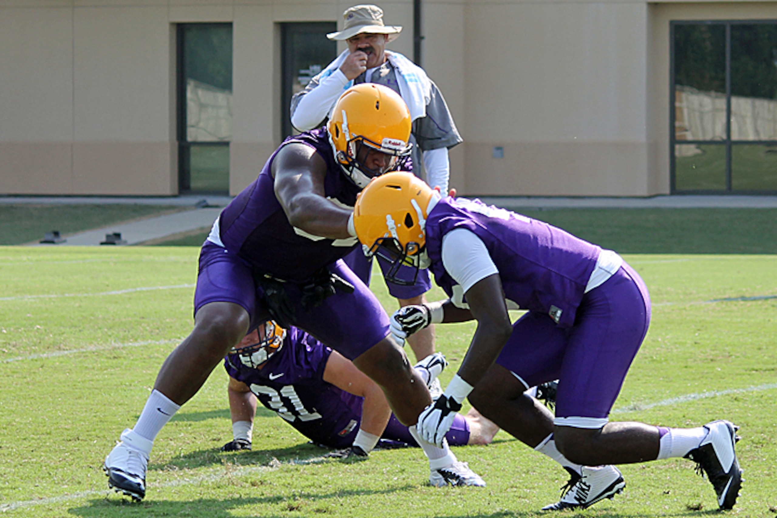 LSU defensive tackle Davon Godchaux (center) works a drill as John Chavis looks on in the background. LSU defensive tackle Davon Godchaux (center) works a drill as John Chavis looks on in the background.