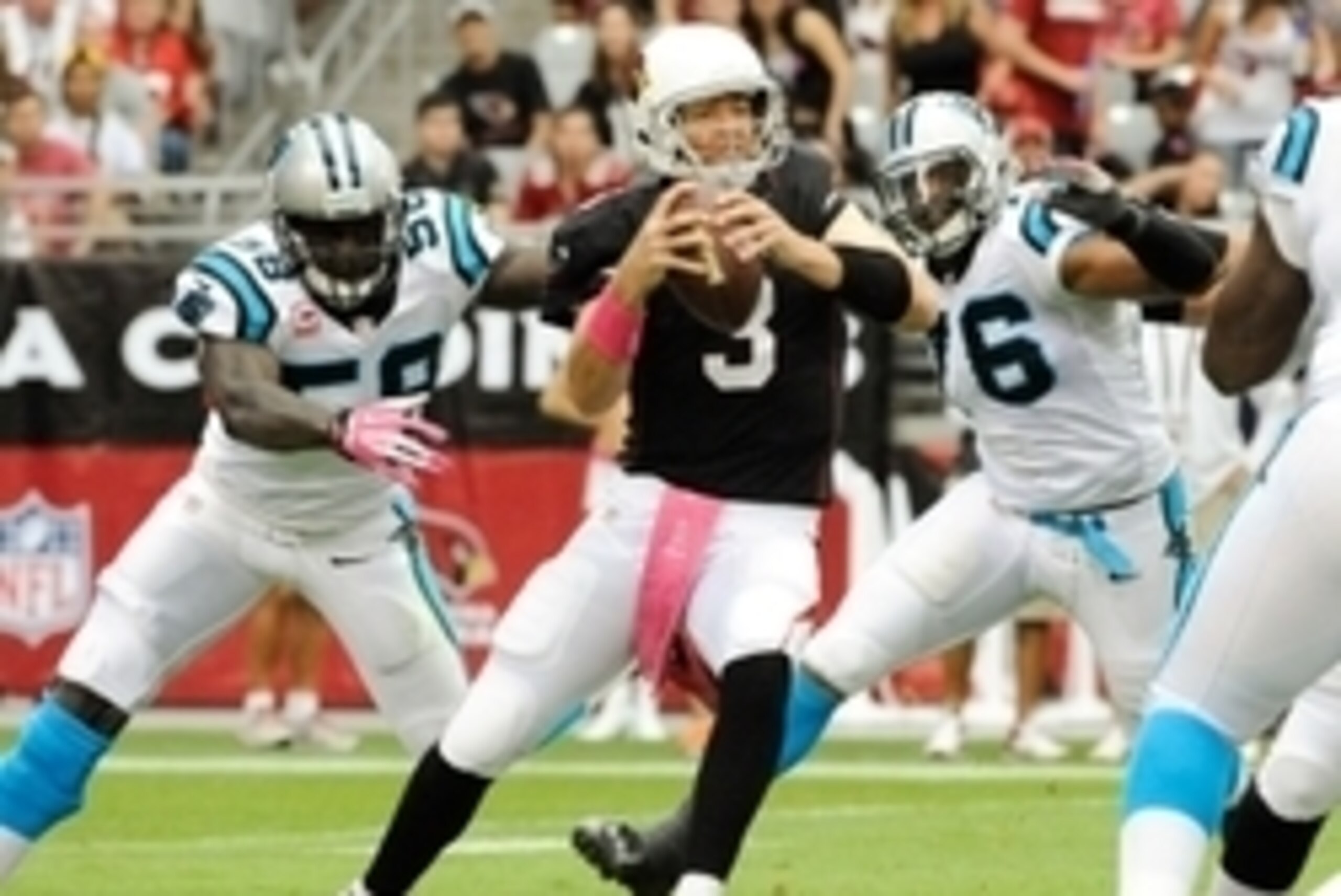 Oct 6, 2013; Phoenix, AZ, USA; Arizona Cardinals quarterback Carson Palmer (3) looks for an open receiver to pass to under pressure from Carolina Panthers linebacker Thomas Davis (58) and defensive end Greg Hardy (76) during the first quarter at Universit