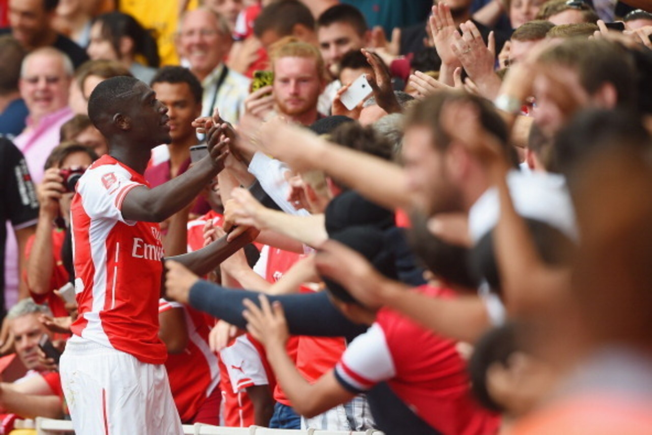 LONDON, ENGLAND - AUGUST 02:  Yaya Sanogo of Arsenal celebrates scoring his 4th goal with fans during the Emirates Cup match between Arsenal and Benfica at the Emirates Stadium on August 2, 2014 in London, England.  (Photo by Michael Regan/Getty Images)