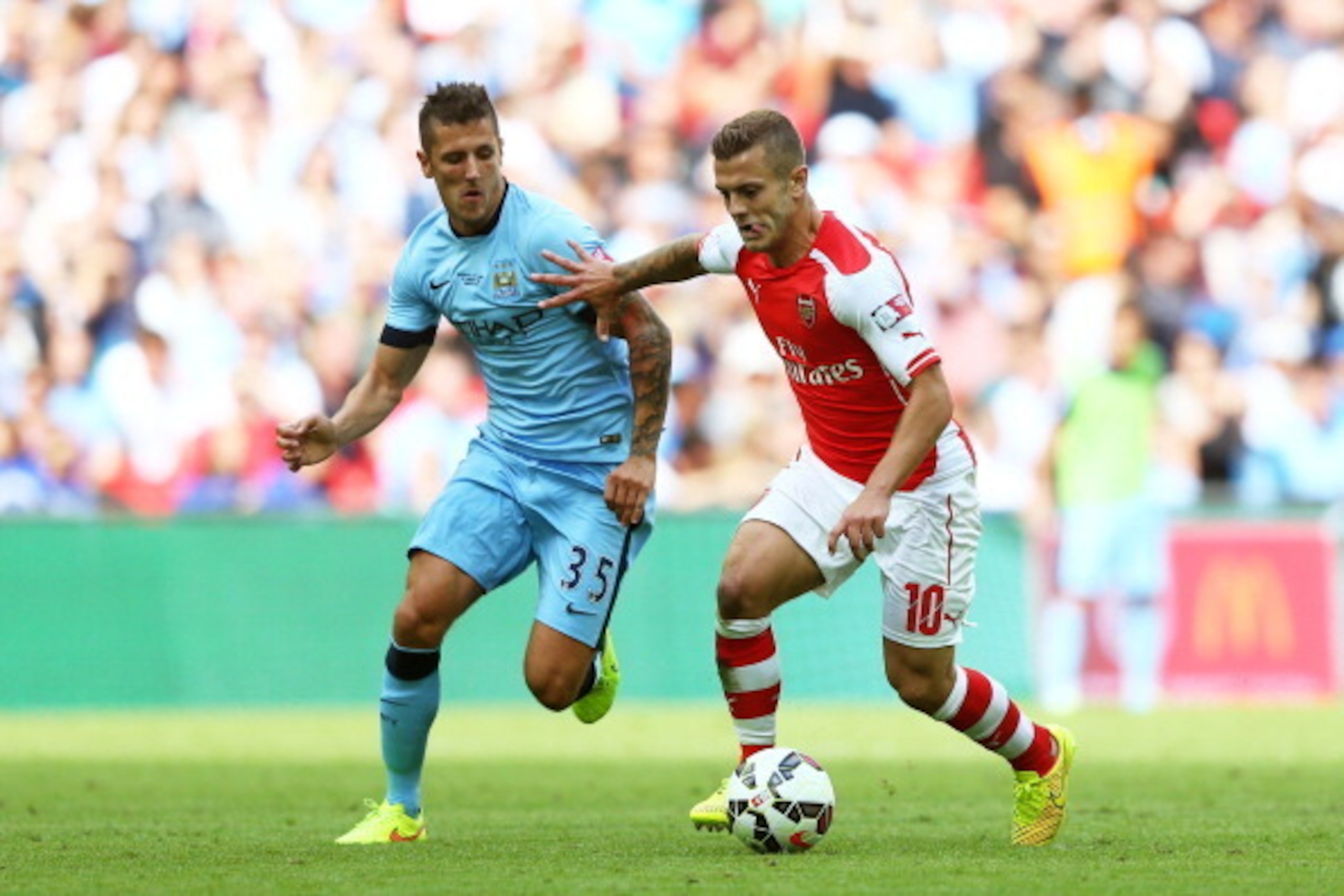 LONDON, ENGLAND - AUGUST 10: Stevan Jovetic of Manchester City competes for the ball with Jack Wilshere of Arsenal during the FA Community Shield match between Manchester City and Arsenal at Wembley Stadium on August 10, 2014 in London, England.  (Photo b