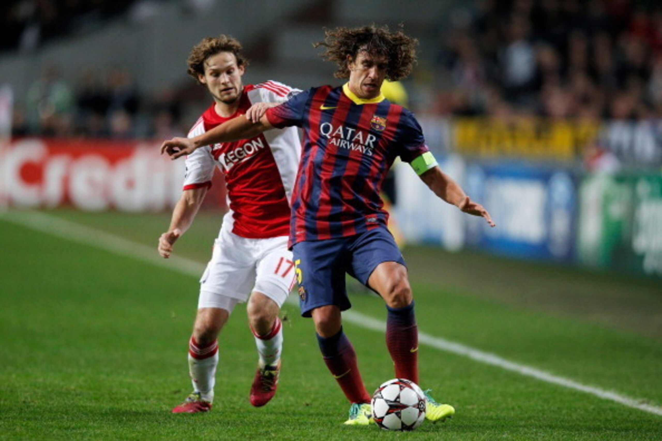 AMSTERDAM, NETHERLANDS - NOVEMBER 26:  Daley Blind of Ajax and Carles Puyol of Barcelona battle for the ball during the UEFA Champions League Group H match between Ajax Amsterdam and FC Barcelona at Amsterdam Arena on November 26, 2013 in Amsterdam, Nethe