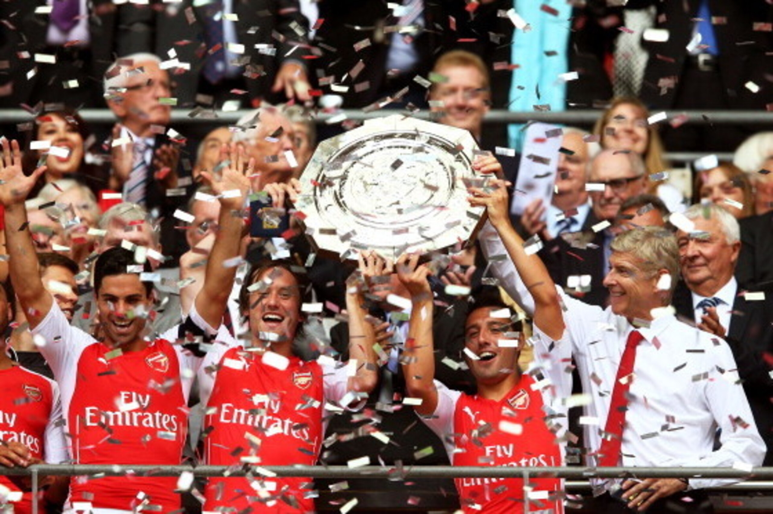 LONDON, ENGLAND - AUGUST 10: Santi Cazorla of Arsenal holds up the trophy watched by Arsene Wenger, manager of Arsenal after the FA Community Shield match between Manchester City and Arsenal at Wembley Stadium on August 10, 2014 in London, England.  (Phot