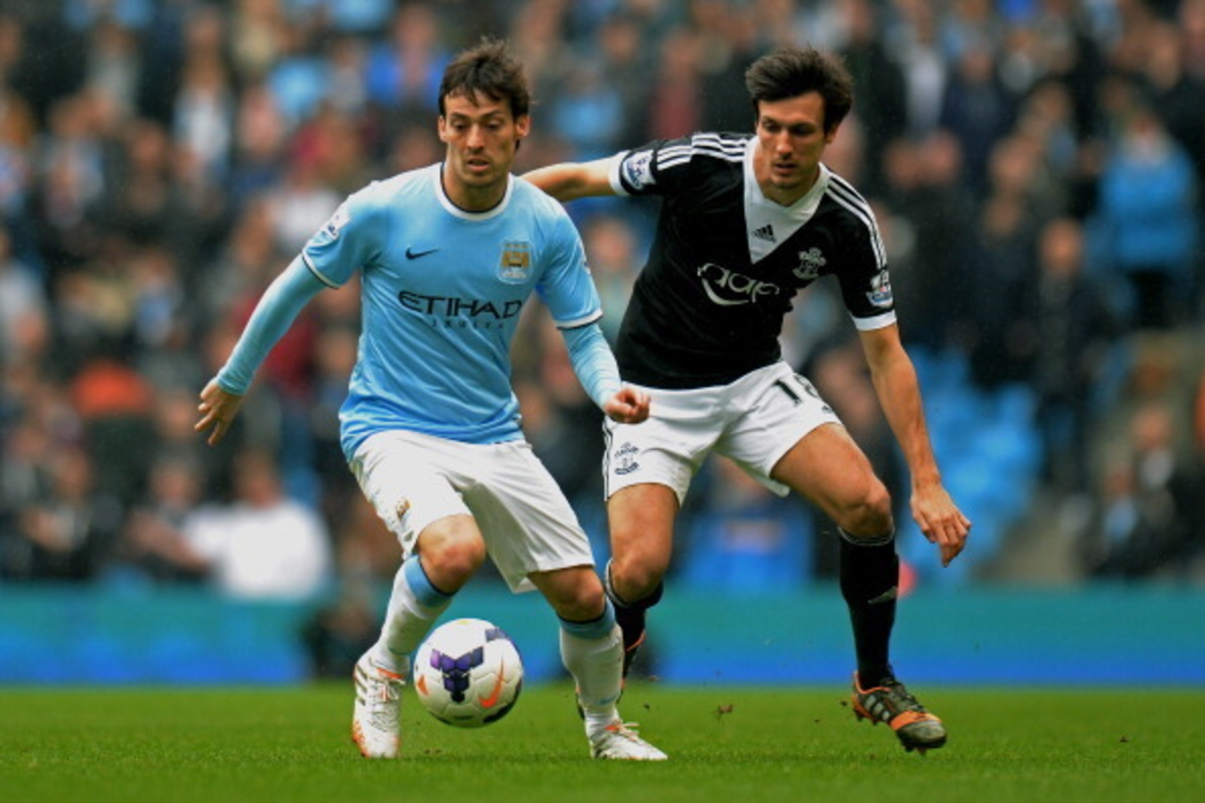 MANCHESTER, ENGLAND - APRIL 05:  David Silva of Manchester City is challenged by Jack Cork of Southampton during the Barclays Premier League match between Manchester City and Southampton at Etihad Stadium on April 5, 2014 in Manchester, England.  (Photo b