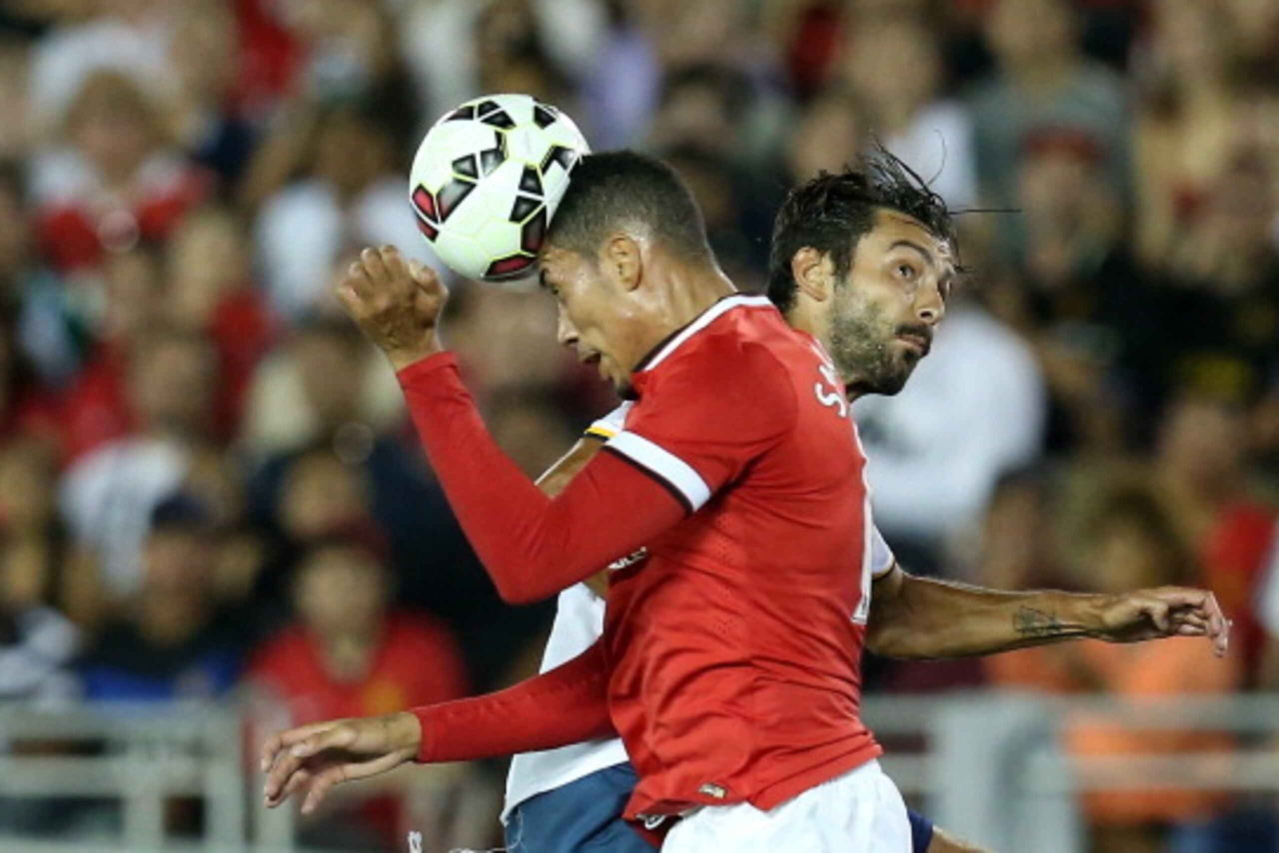 PASADENA, CA - JULY 23:  Chris Smalling #12 of Manchester United heads the ball away from Baggio Husidic #6 of the Los Angeles Galaxy at the Rose Bowl on July 23, 2014 in Pasadena, California.  (Photo by Stephen Dunn/Getty Images)