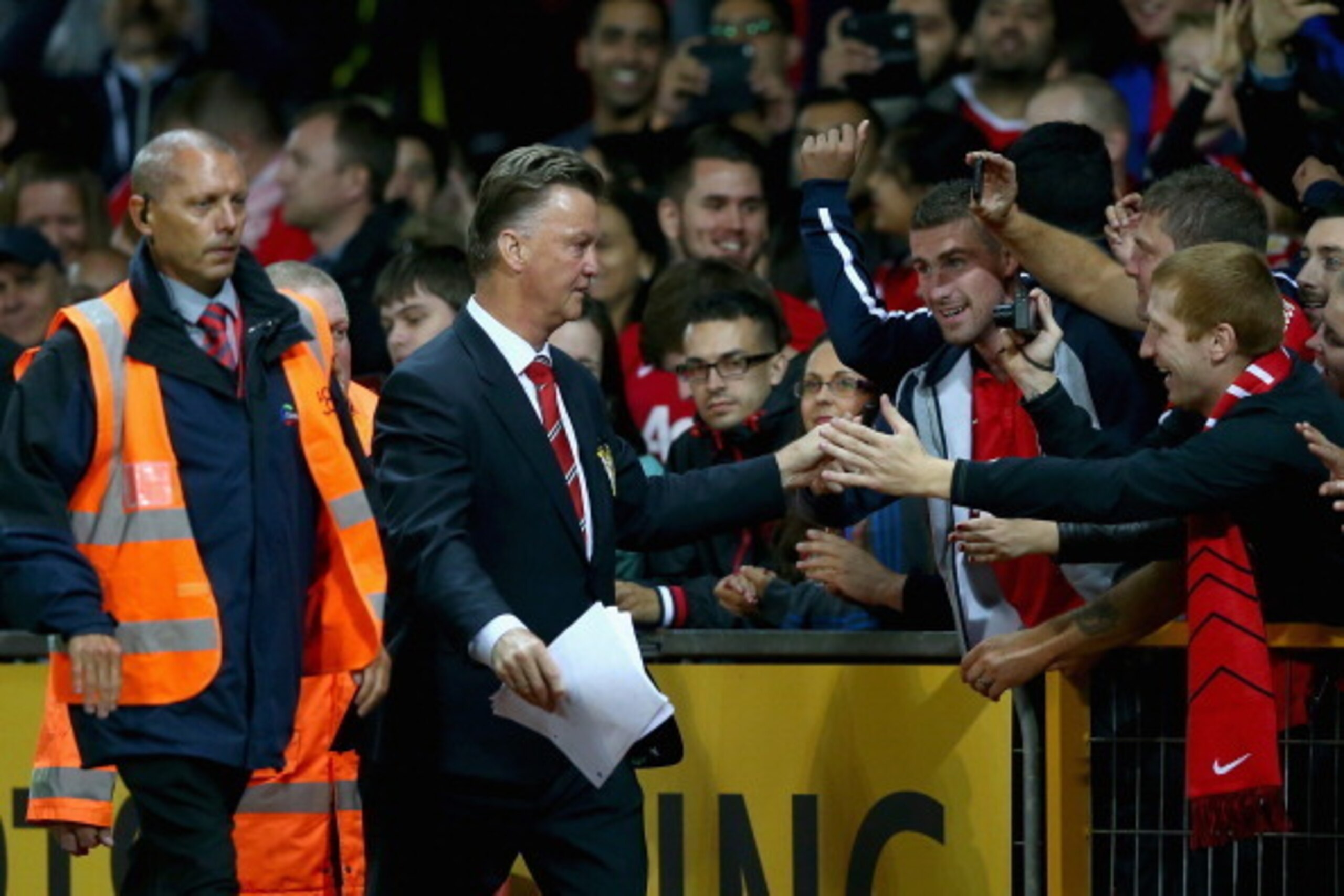 MANCHESTER, ENGLAND - AUGUST 12:  Manchester United manager Louis Van Gaal is congratulated by the fans after winning his home debut in the Pre Season Friendly match between Manchester United and Valencia at Old Trafford on August 12, 2014 in Manchester, 
