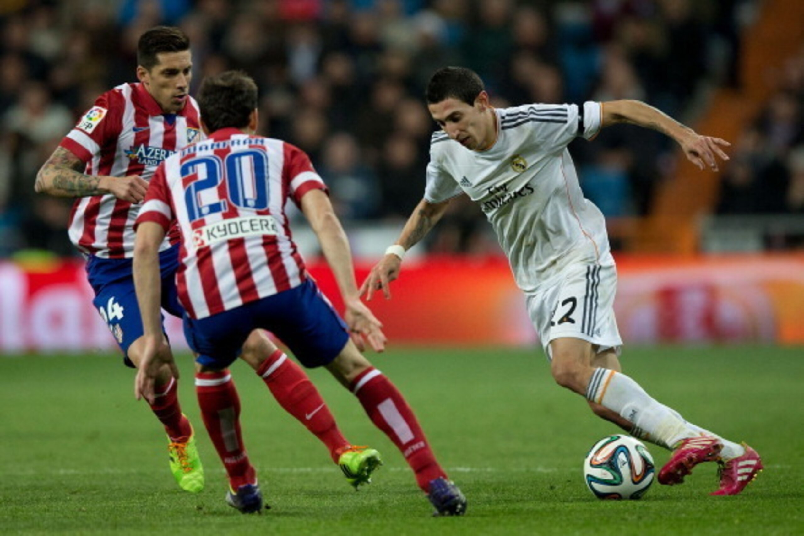 MADRID, SPAIN - FEBRUARY 05: Angel Di Maria (R) of Real Madrid CF competes for the ball with Juan Francisco Torres alias Juanfran (2ndR) of Atletico de Madrid and his team mate Jose Sosa during the Copa del Rey semifinal first leg match between Real Madri MADRID, SPAIN - FEBRUARY 05: Angel Di Maria (R) of Real Madrid CF competes for the ball with Juan Francisco Torres alias Juanfran (2ndR) of Atletico de Madrid and his team mate Jose Sosa during the Copa del Rey semifinal first leg match between Real Madri