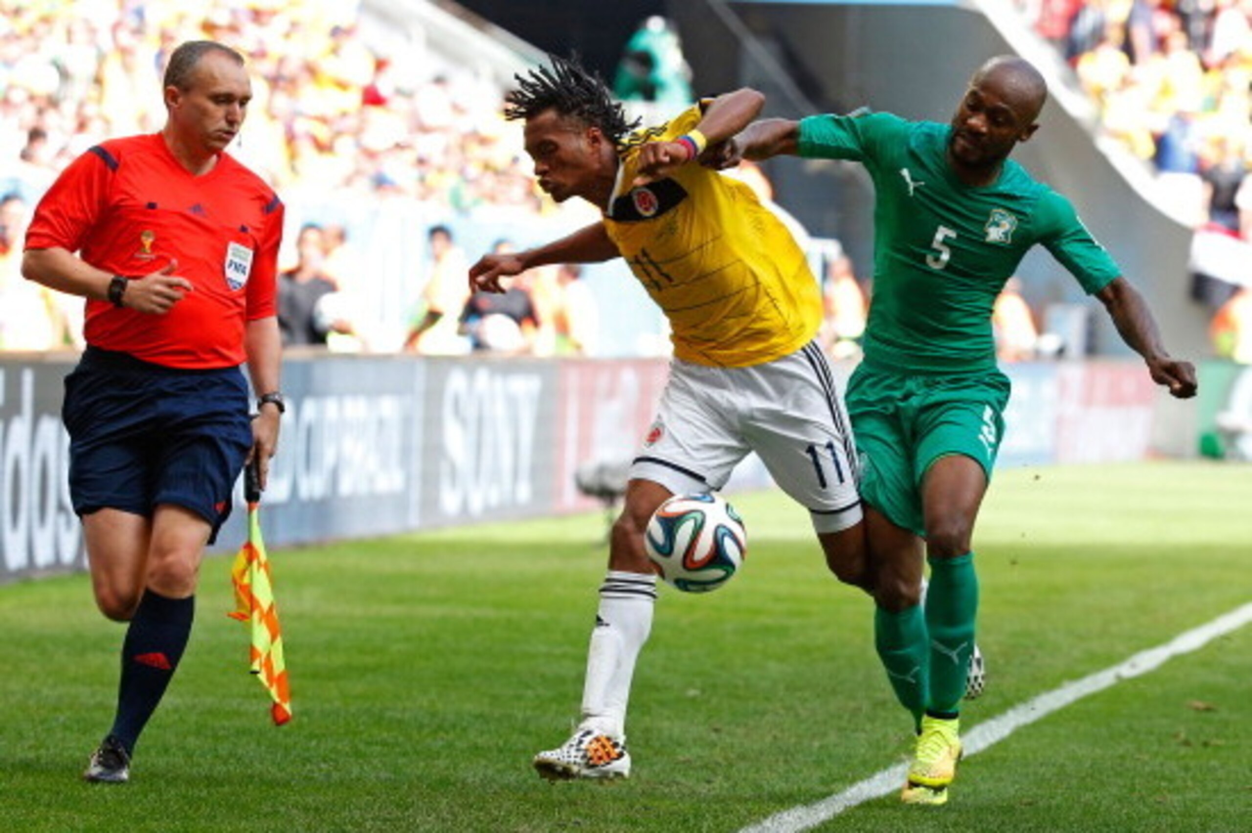 BRASILIA, BRAZIL - JUNE 19: Didier Zokora of the Ivory Coast competes for the ball with Juan Guillermo Cuadrado of Colombia during the 2014 FIFA World Cup Brazil Group C match between Colombia and Cote D'Ivoire at Estadio Nacional on June 19, 2014 in Bras