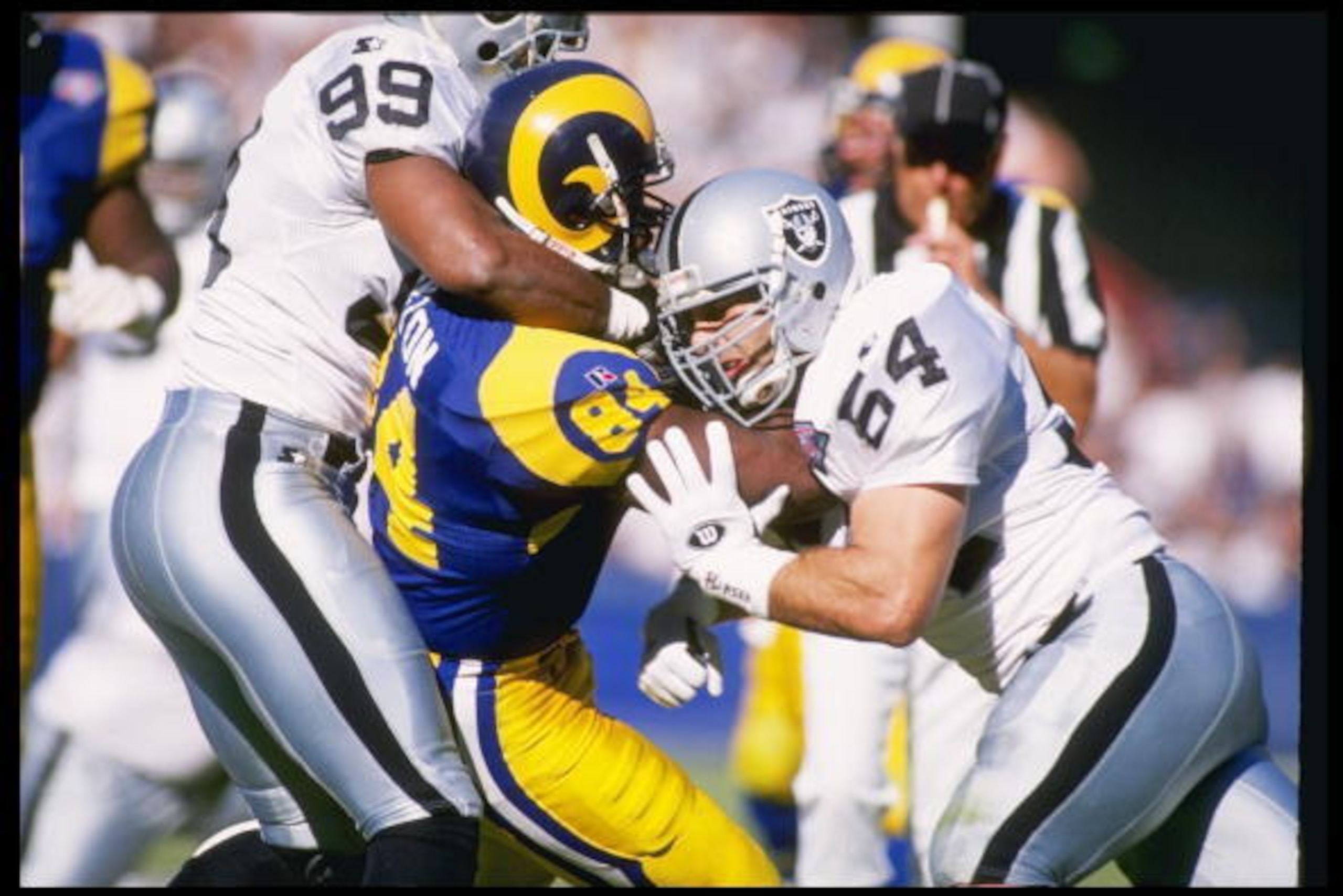 13 Nov 1994:  Wide receiver Troy Drayton of the Los Angeles Rams gets tackled by a pair of Los Angeles Raiders players during a game at Anaheim Stadium in Anaheim, California.  The Raiders won the game, 20-17. Mandatory Credit: Al Bello  /Allsport