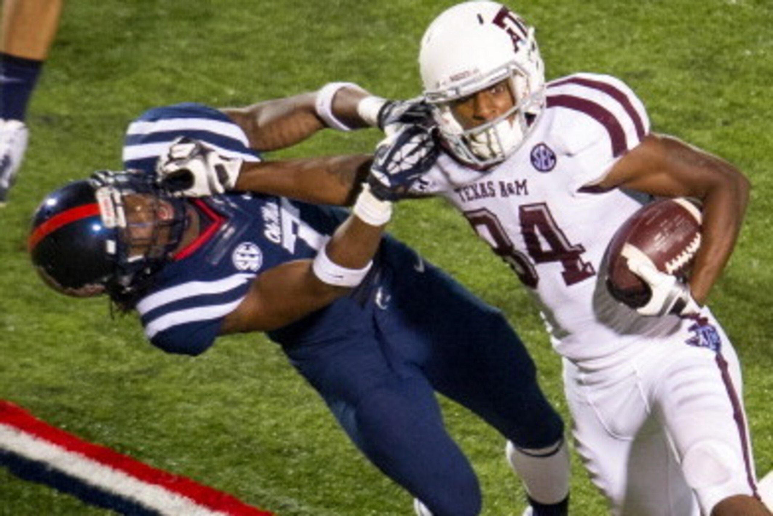 OXFORD, MS - OCTOBER 12: Wide receiver Malcome Kennedy #84 of the Texas A&M Aggies stiff arms defensive back Trae Elston #7 of the Ole Miss Rebels during the second half of play on October 12, 2013 at Vaught-Hemingway Stadium in Oxford, Mississippi. Texas
