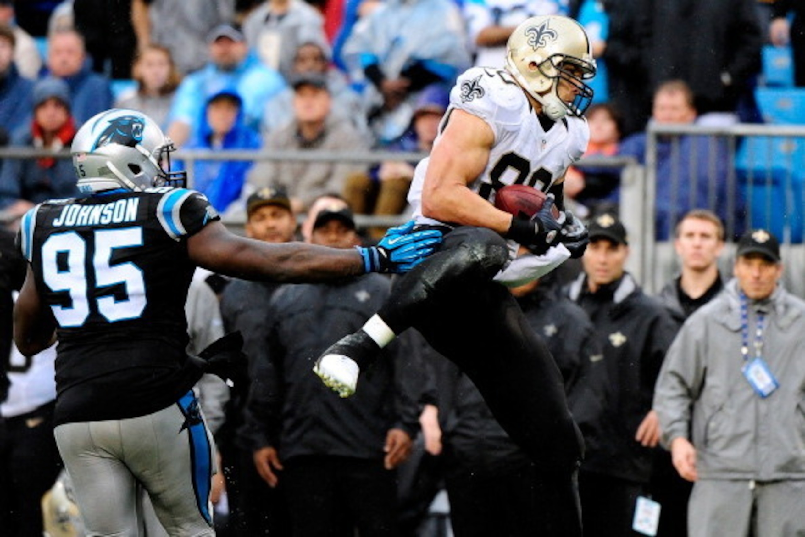 CHARLOTTE, NC - DECEMBER 22:  Jimmy Graham #80 of the New Orleans Saints makes a catch as Charles Johnson #95 of the Carolina Panthers looks on during their game at Bank of America Stadium on December 22, 2013 in Charlotte, North Carolina. The Panthers wo