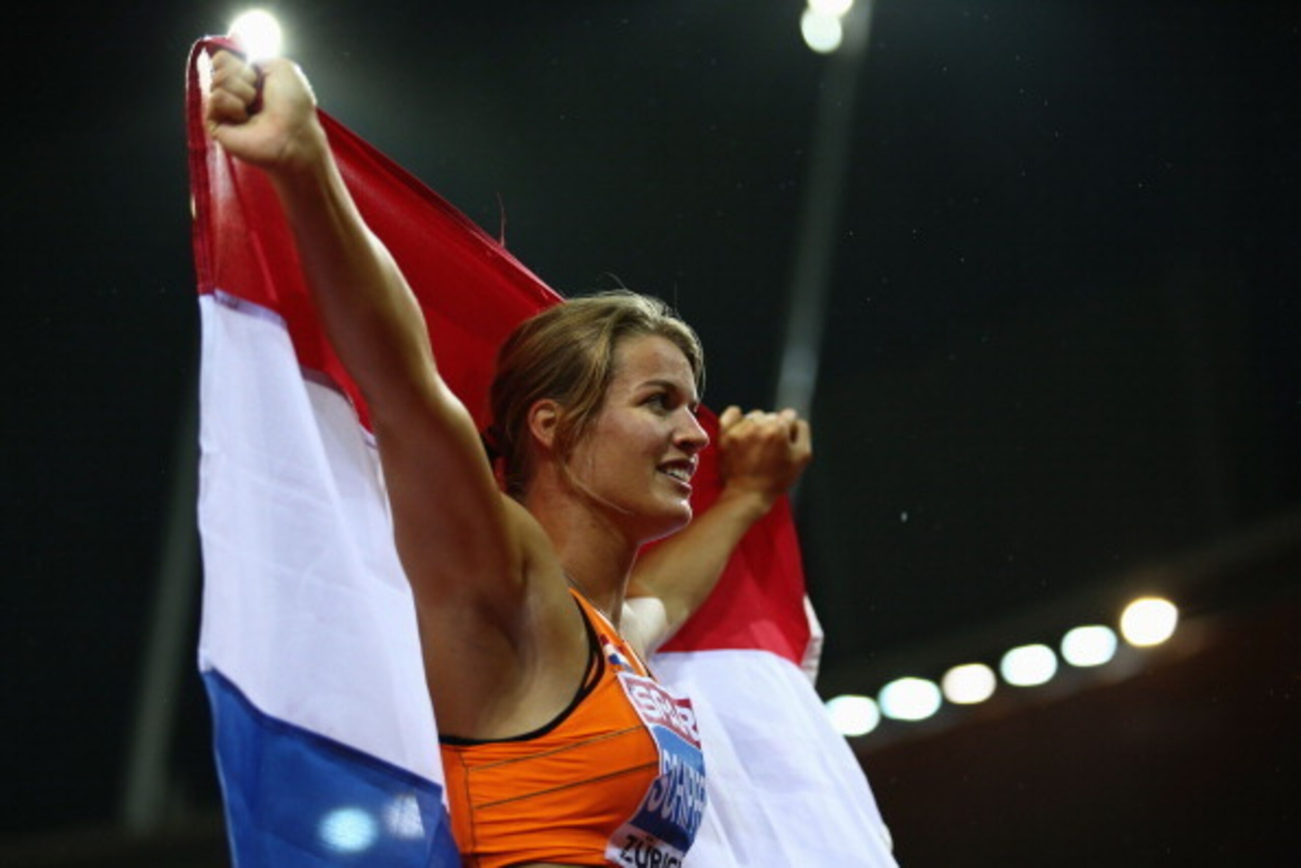 ZURICH, SWITZERLAND - AUGUST 13: Dafne Schippers of the Netherlands celebrates with the Dutch national flag after claiming gold in the Women's 100 metres final during day two of the 22nd European Athletics Championships at Stadium Letzigrund on August 13 ZURICH, SWITZERLAND - AUGUST 13: Dafne Schippers of the Netherlands celebrates with the Dutch national flag after claiming gold in the Women's 100 metres final during day two of the 22nd European Athletics Championships at Stadium Letzigrund on August 13