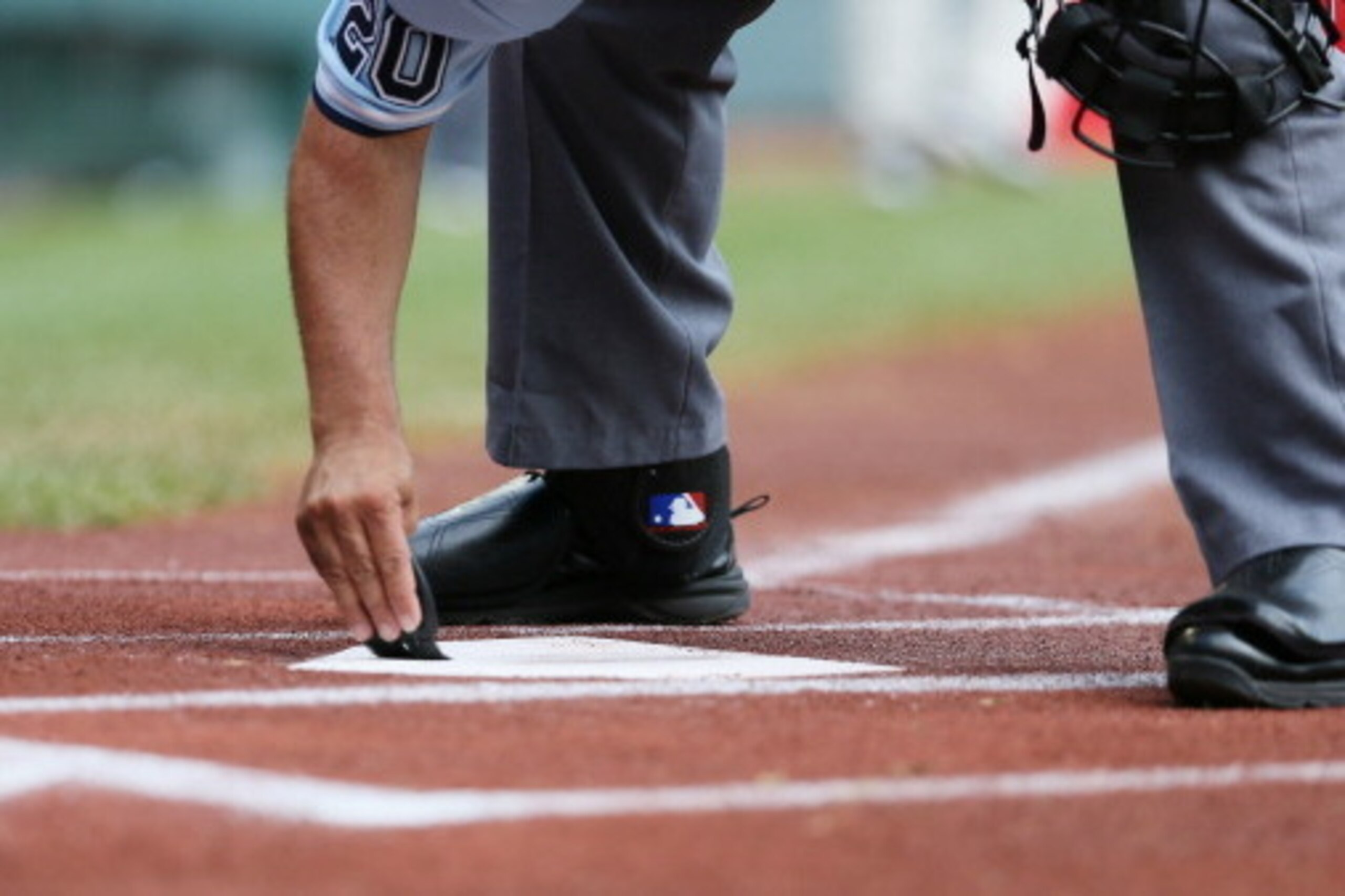 WILLIAMSPORT, PA - AUGUST 25:  The home plate umpire cleans the plate between innings of the West team from Chula Vista, Ca and the Tokyo, Japan team during the fourth inning of the Little League World Series Championship game on August 25, 2013 in Willia