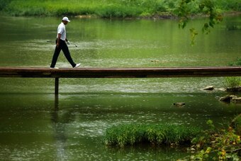 LOUISVILLE, KY - AUGUST 08:  Tiger Woods of the United States walks over a bridge to the ninth hole during the second round of the 96th PGA Championship at Valhalla Golf Club on August 8, 2014 in Louisville, Kentucky.  (Photo by Andy Lyons/Getty Images)