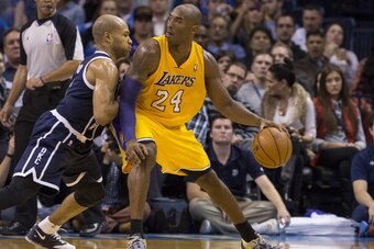 OKLAHOMA CITY, OK - DECEMBER 13:  Kobe Bryant #24 of the Los Angeles Lakers handles the ball against Derek Fisher #6 of the Oklahoma City Thunder at the Chesapeake Energy Arena on December 13, 2013 in Oklahoma City, Oklahoma. NOTE TO USER:  User expressly