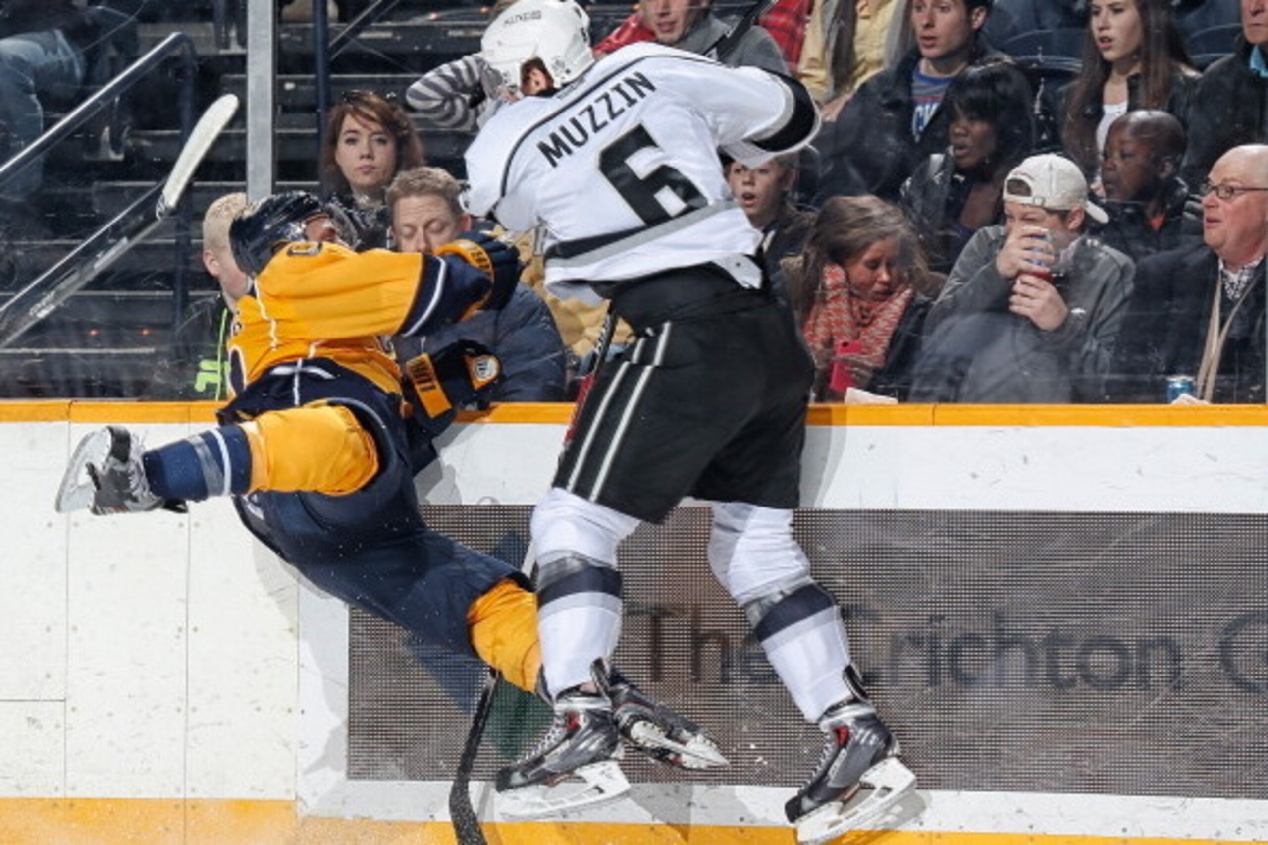 NASHVILLE, TN - DECEMBER 28: Jake Muzzin #6 of the Los Angeles Kings checks Nick Spaling #13 of the Nashville Predators along the boards at Bridgestone Arena on December 28, 2013 in Nashville, Tennessee. (Photo by John Russell/NHLI via Getty Images)