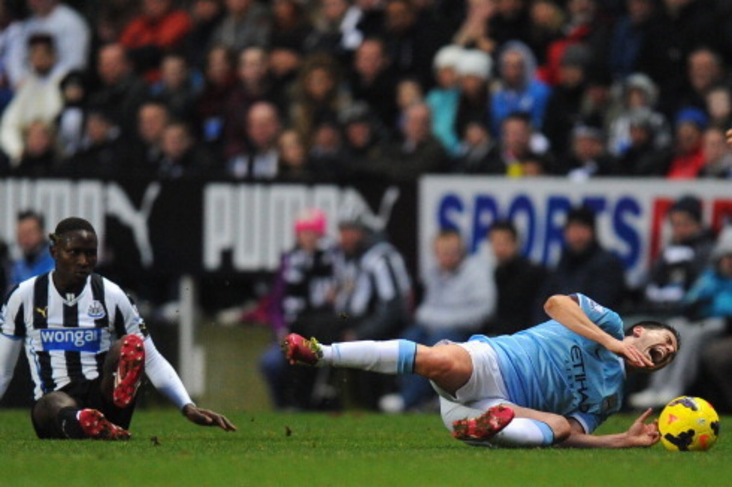 NEWCASTLE UPON TYNE, ENGLAND - JANUARY 12:  Newcastle player Mapou Yanga-Mbiwa (l) fouls Samir Nasri who is later stretchered off during the Barclays Premier League match between Newcastle United and Manchester City at St James' Park on January 12, 2014 i