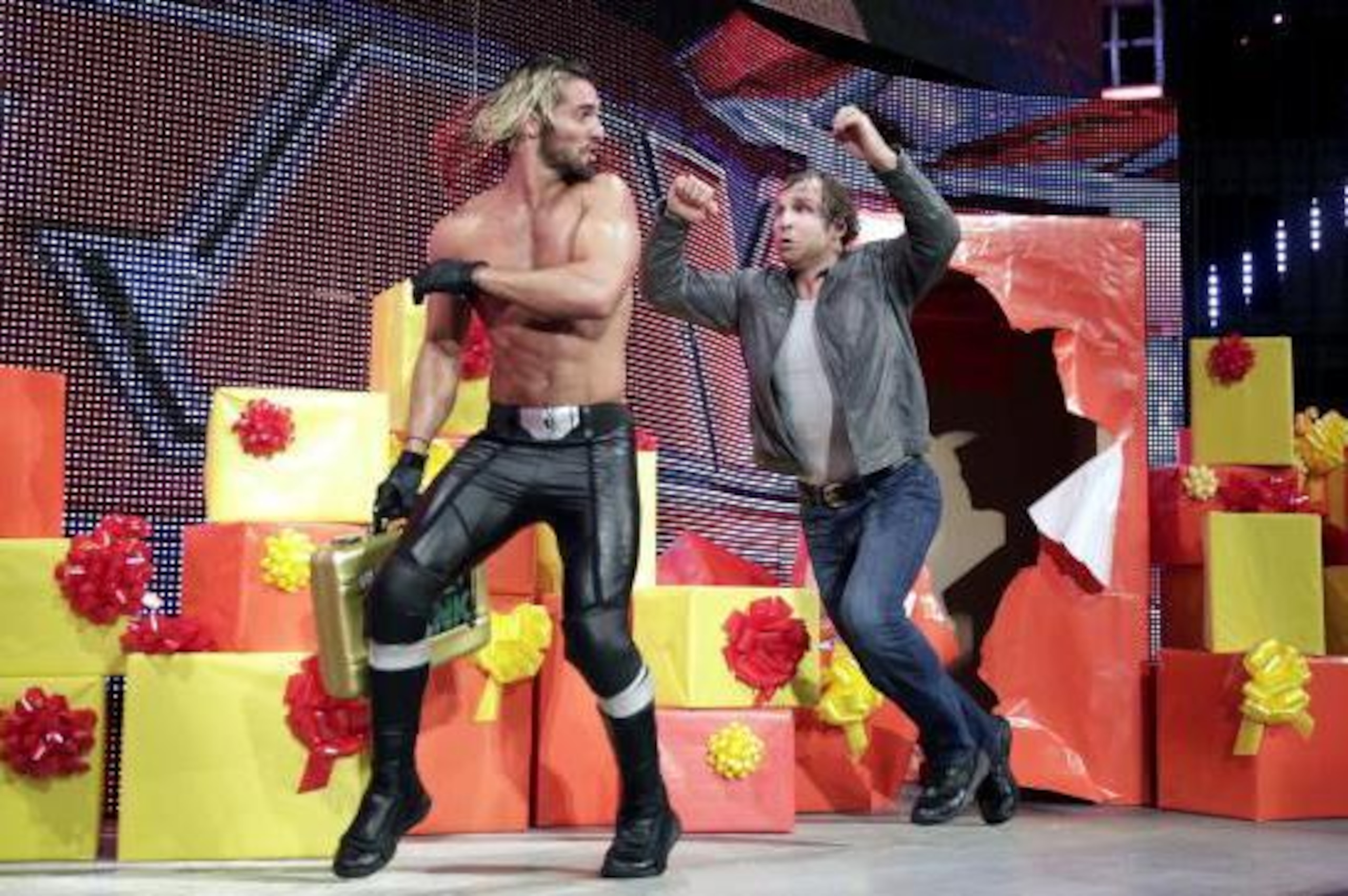 Dean Ambrose leaps out of a present to chase Seth Rollins. Dean Ambrose leaps out of a present to chase Seth Rollins.
